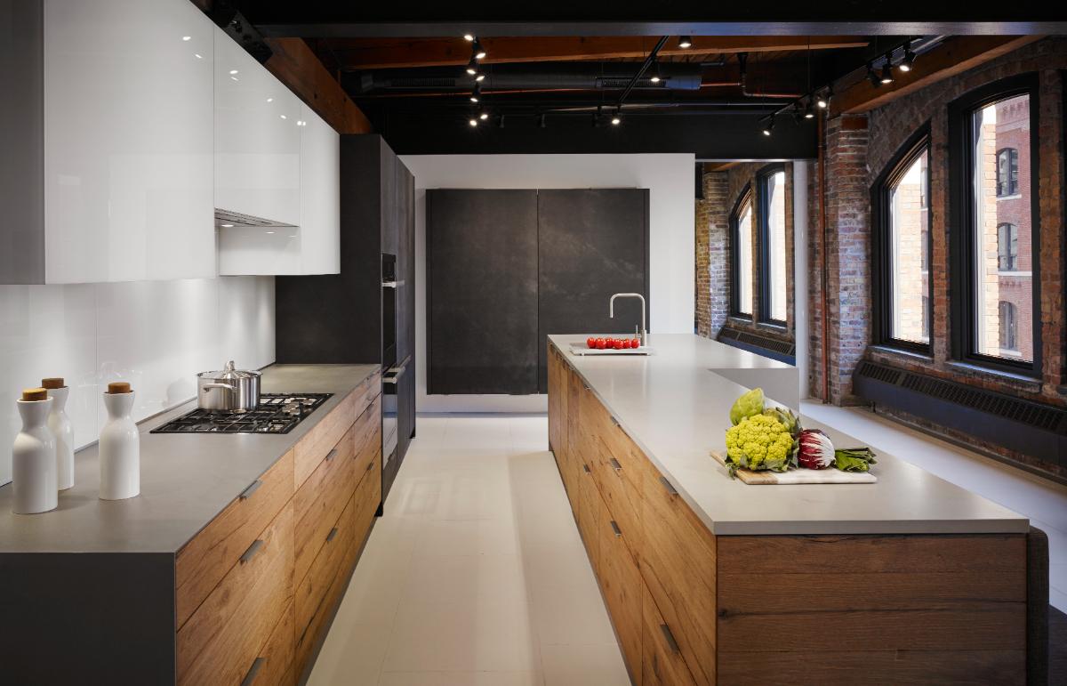 Miele vs Wolf kitchen comparison featuring a contemporary luxury kitchen with minimalist cabinetry, a large island and premium integrated appliances.