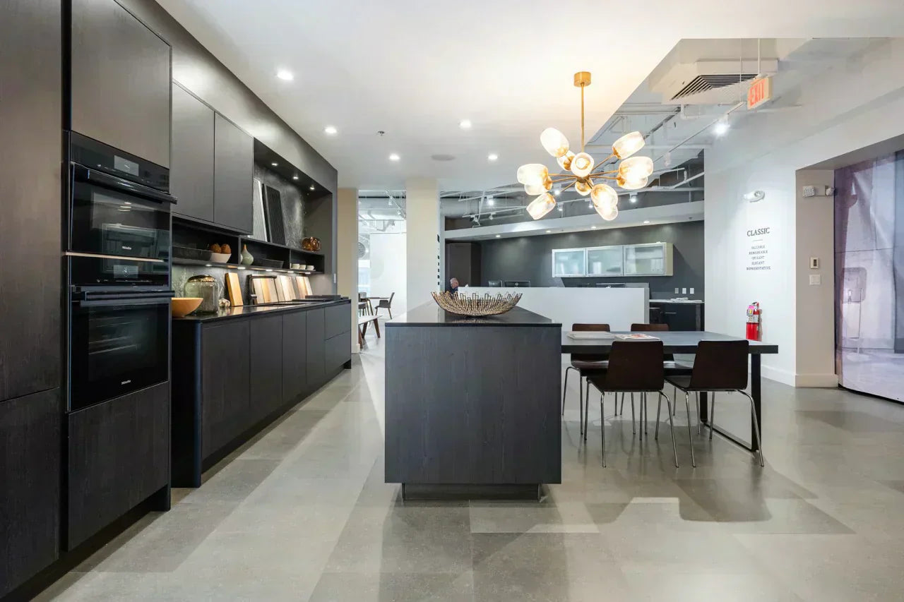 Modern kitchen with dark cabinetry, a central island and integrated appliances showcasing affordable kitchen renovations with a premium finish.