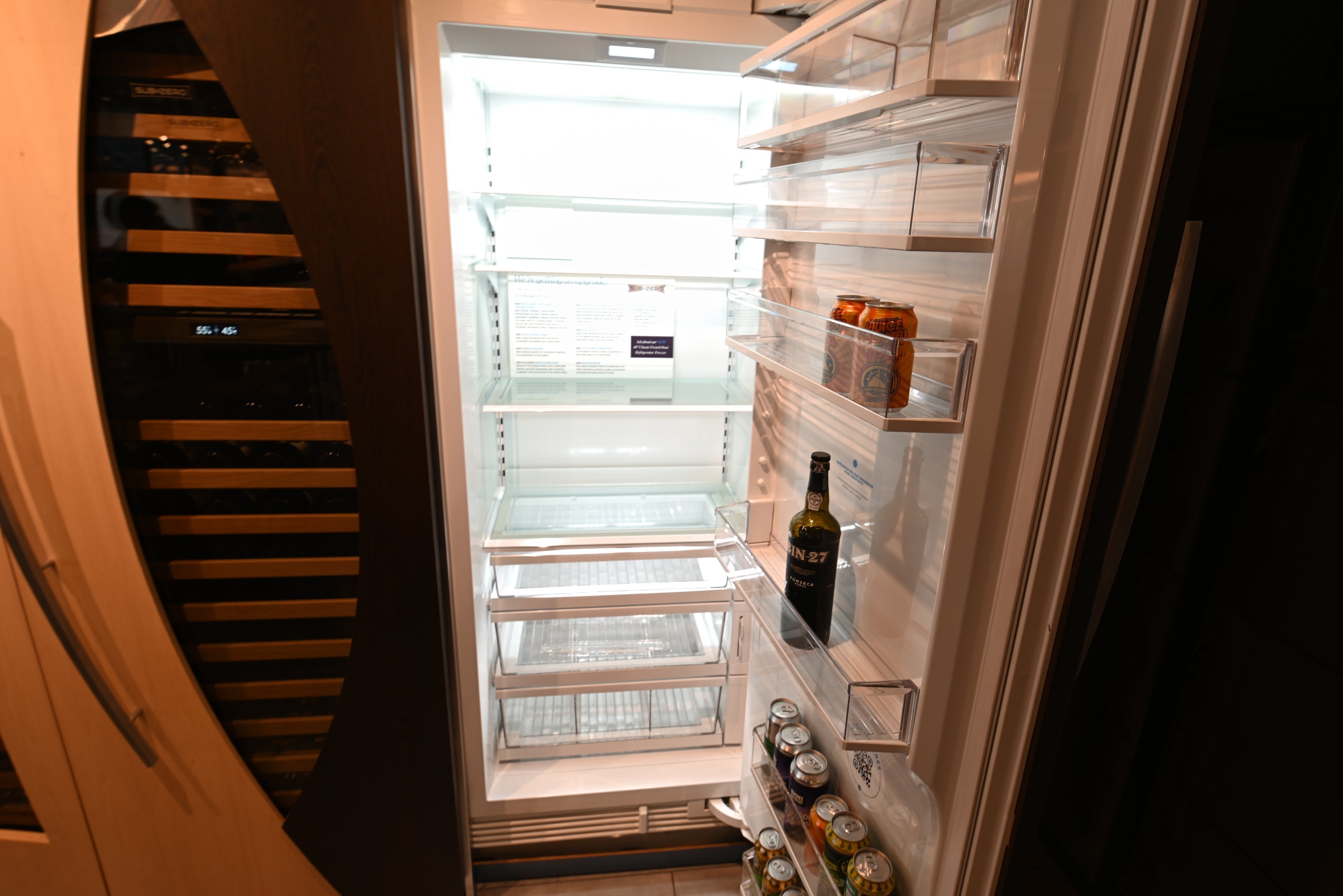 Sub-Zero refrigerator with an open interior showcasing adjustable shelves, storage drawers and integrated wine refrigeration.