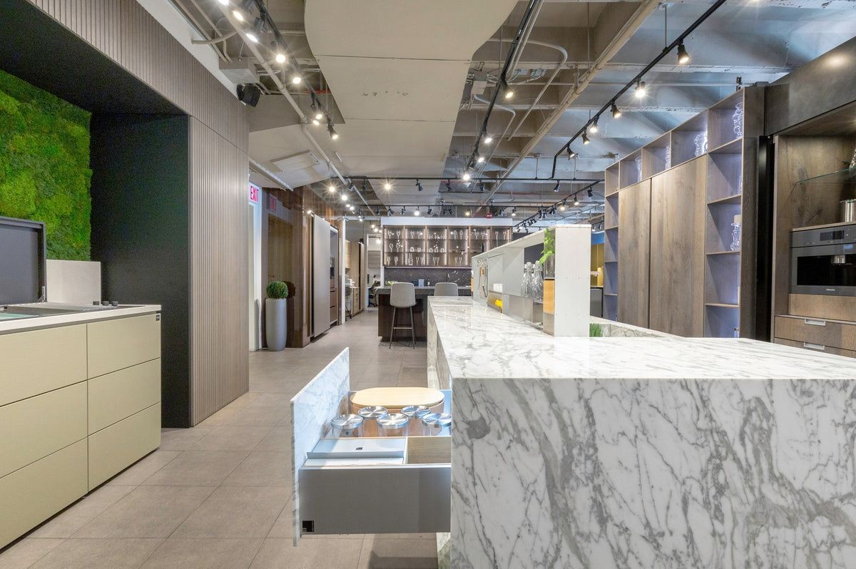 Modern kitchen showroom with marble worktops and cabinetry suitable for recovery through green demolition.