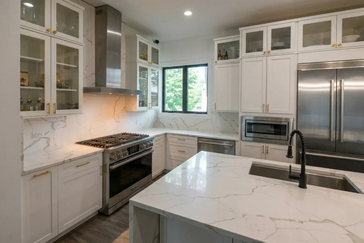 Kitchen cabinet ideas with white shaker cabinets, marble-look worktops and stainless steel appliances.