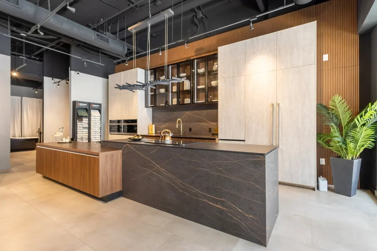 Modern kitchen showrooms displaying a luxury kitchen with a dark stone island, wood cabinetry and premium integrated appliances.