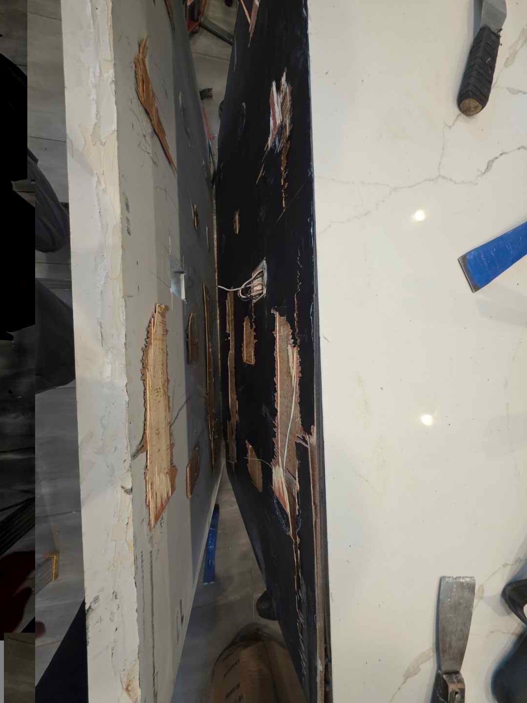 Aurora Circ white and black stone countertop slabs with veining and chipped exposed edges in a showroom setting