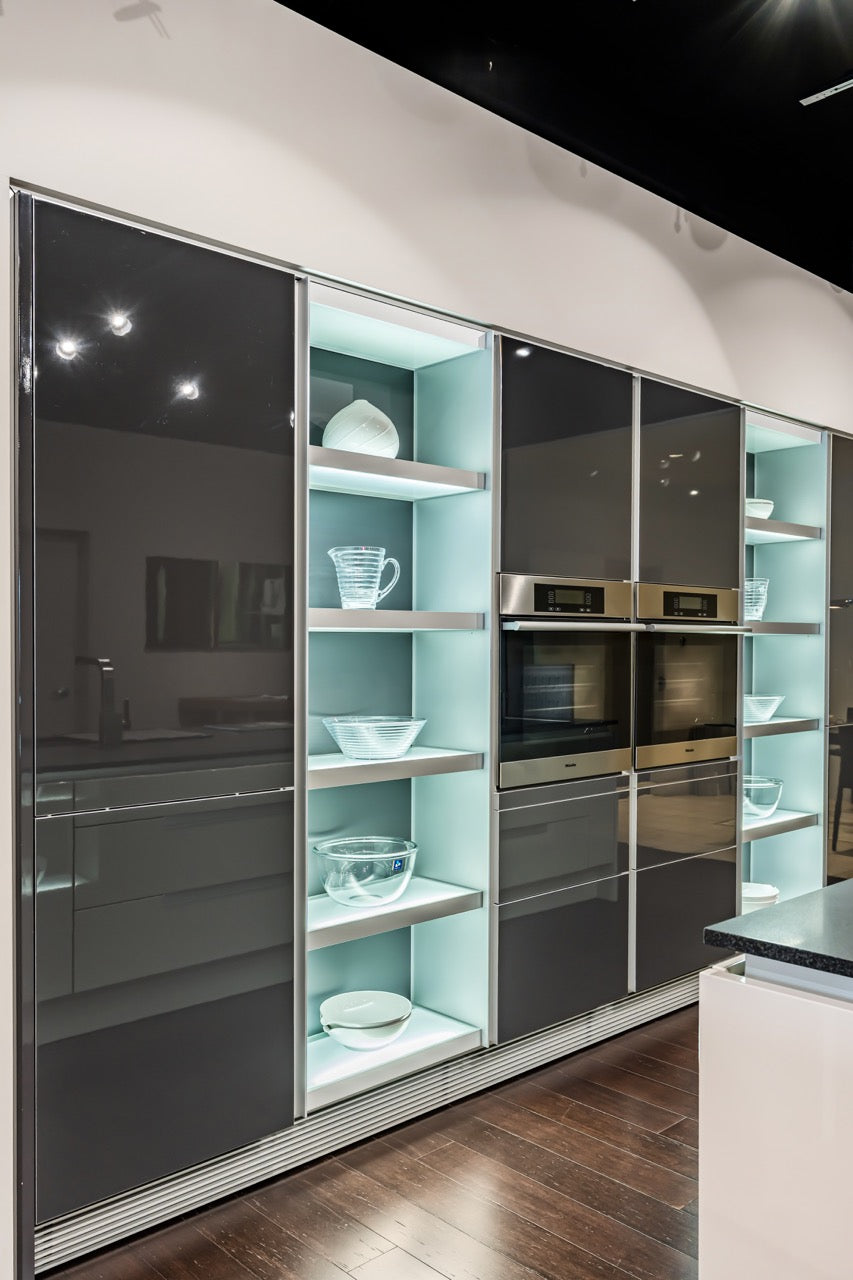 Poggenpohl luxury kitchen display featuring Miele wall ovens and custom lighting