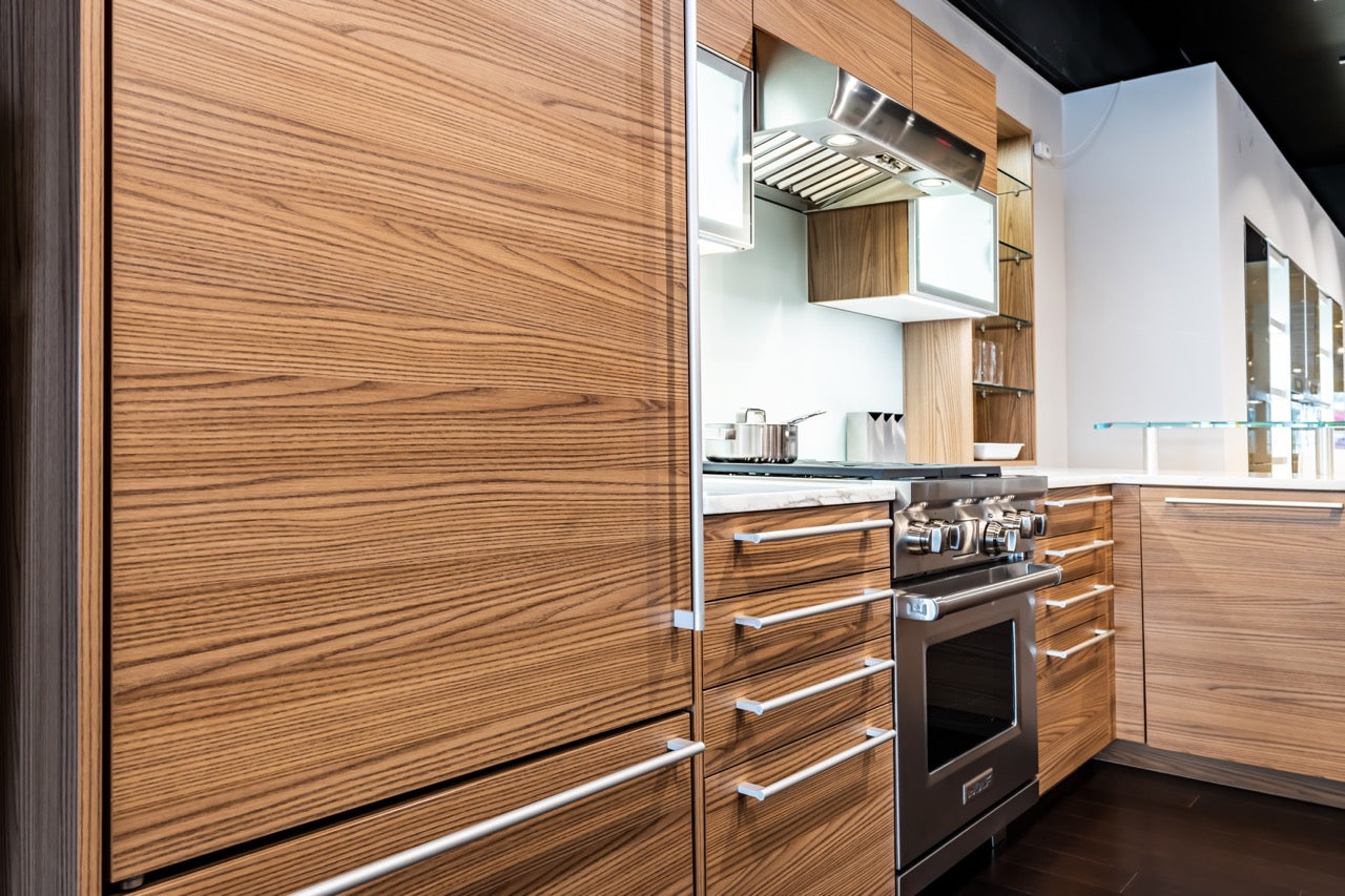 Poggenpohl brown elm kitchen display featuring Sub-Zero refrigerator and Wolf wall oven