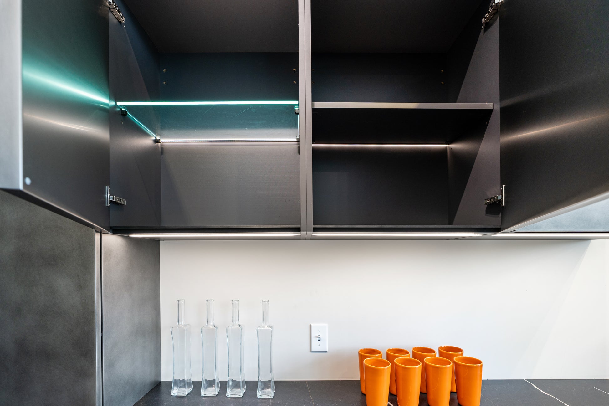 Aster Cucine contemporary kitchen layout featuring high gloss slab doors and a minimalist copper or steel toned metallic island