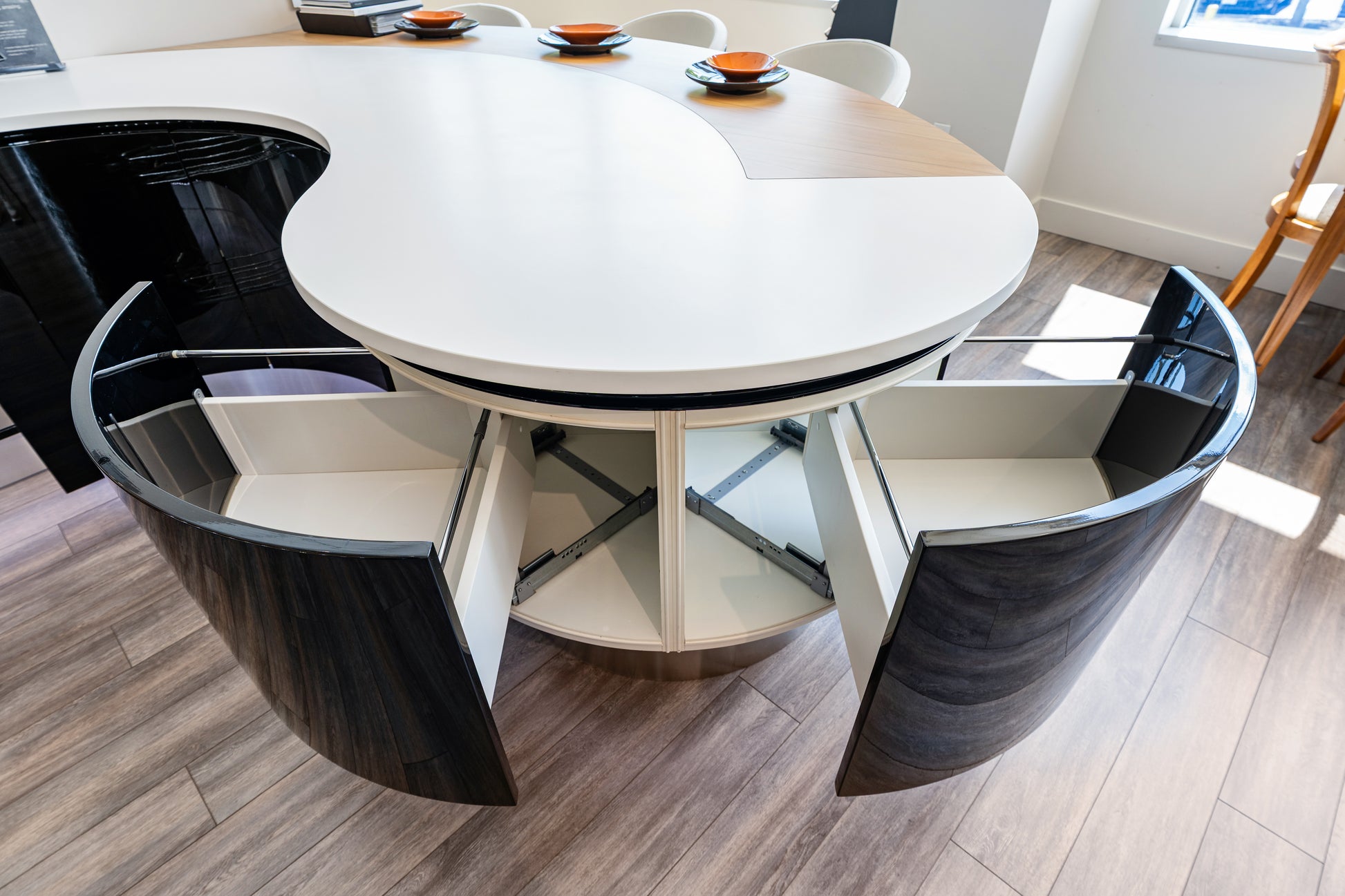 Aster Cucine contemporary curved kitchen layout featuring a minimalist contoured island and integrated luxury appliances