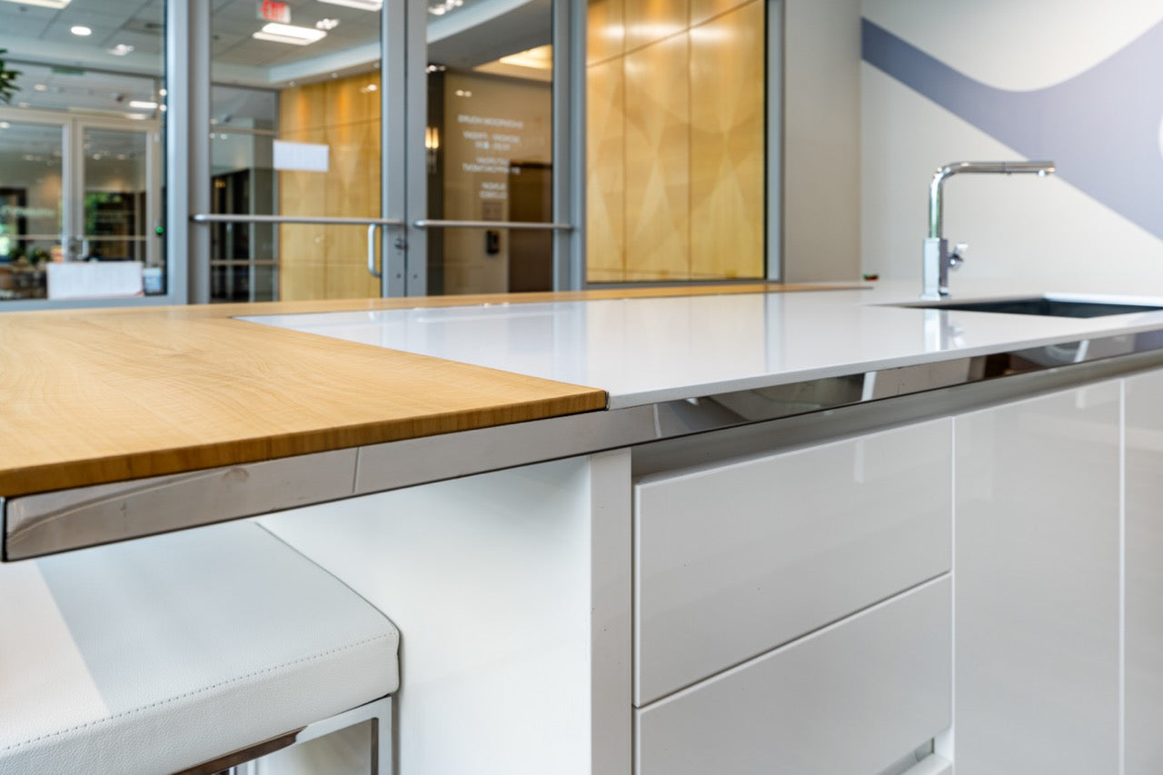 Aster Cucine contemporary white kitchen layout featuring a minimalist island and integrated handleless C channel rails