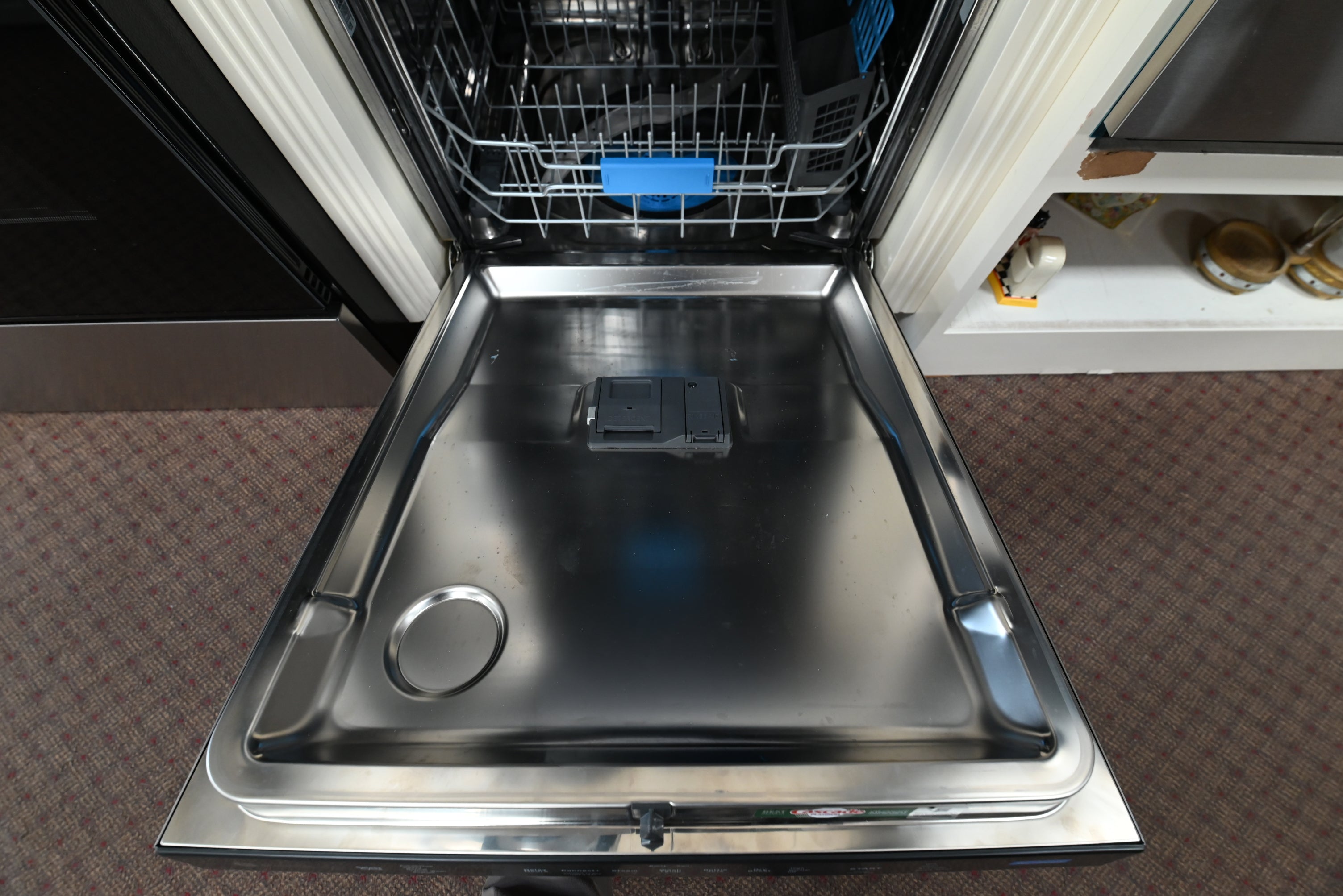 Modern custom kitchen layout with a flush-mounted 24 inch GE Profile smart dishwasher integrated next to wood cabinets