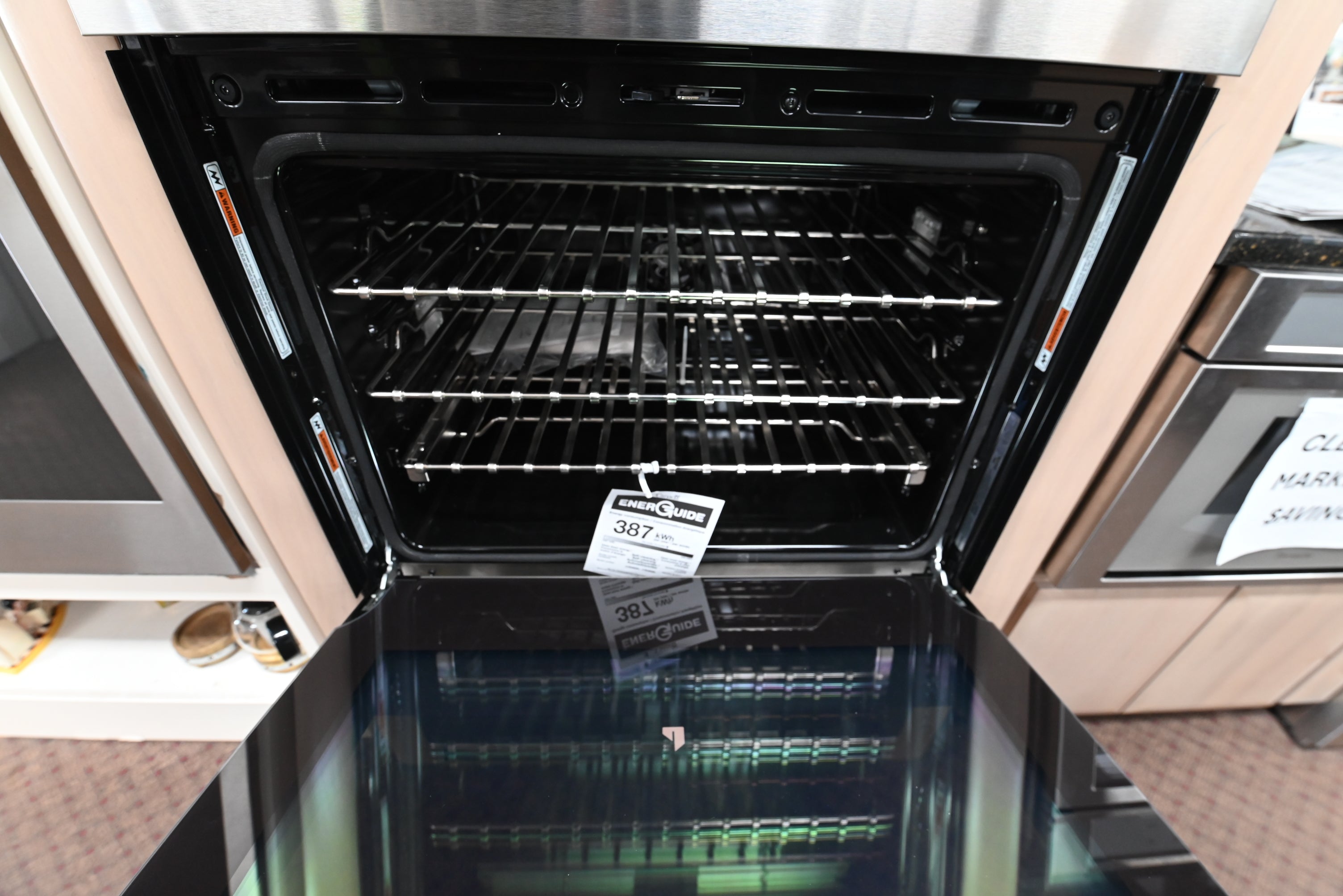 JennAir NOIR double oven doors open showing jet black porcelain interior with cinematic halogen lighting