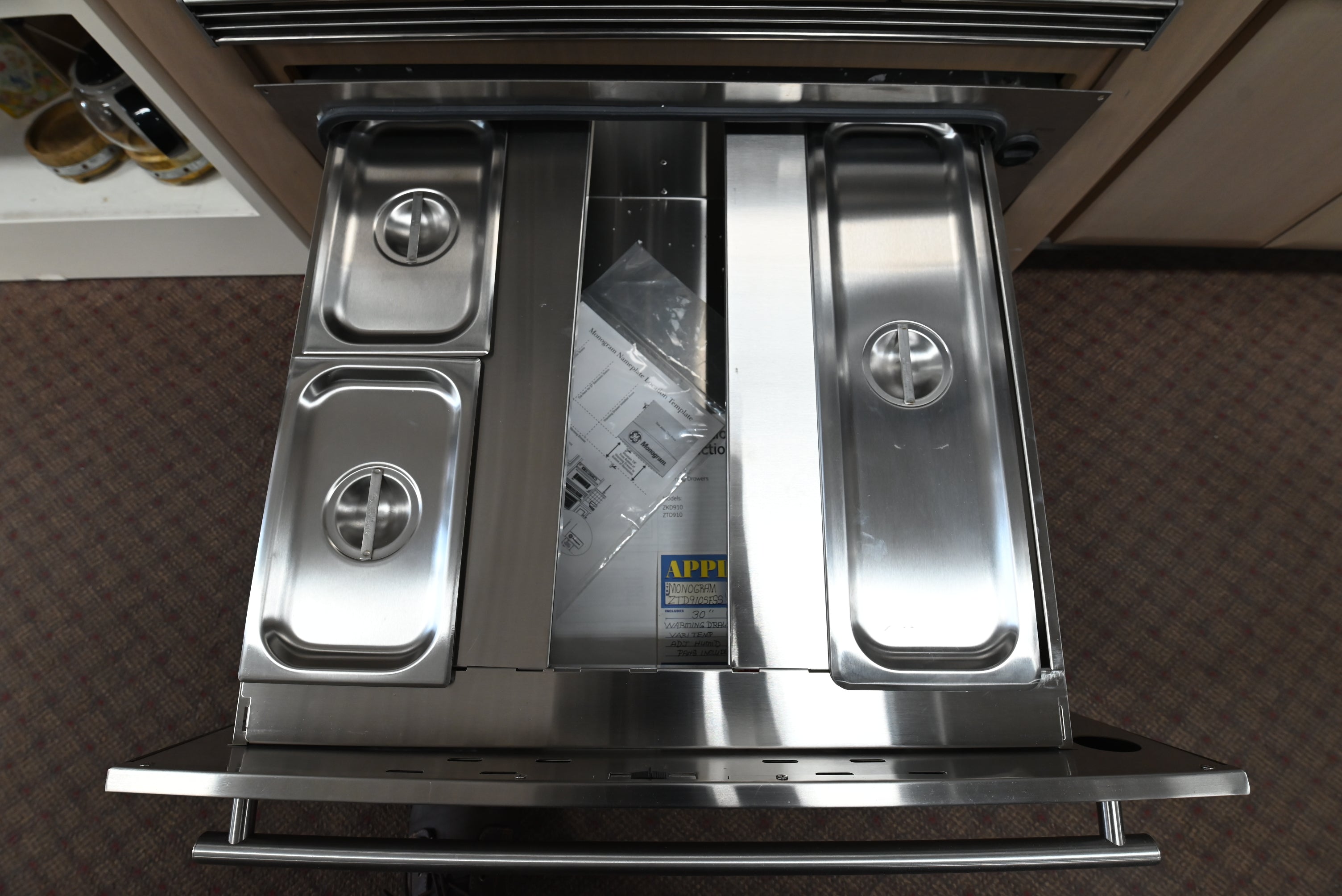 Monogram 30 inch warming drawer installed flush inset beneath a built in wall oven