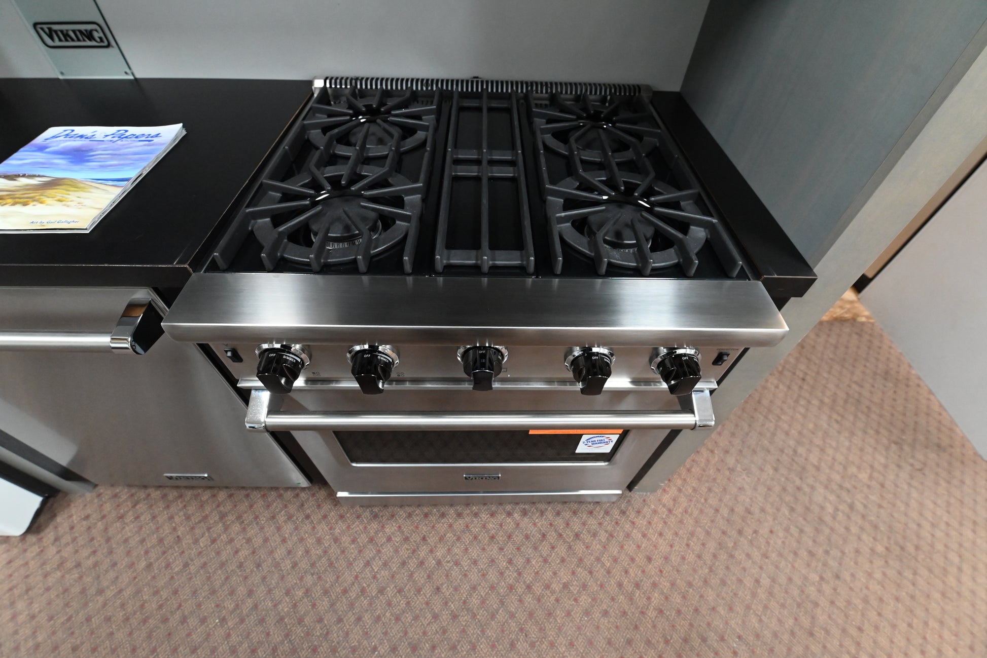 Luxury 30 inch Viking gas range cooktop showing four open burners and continuous cast iron grates