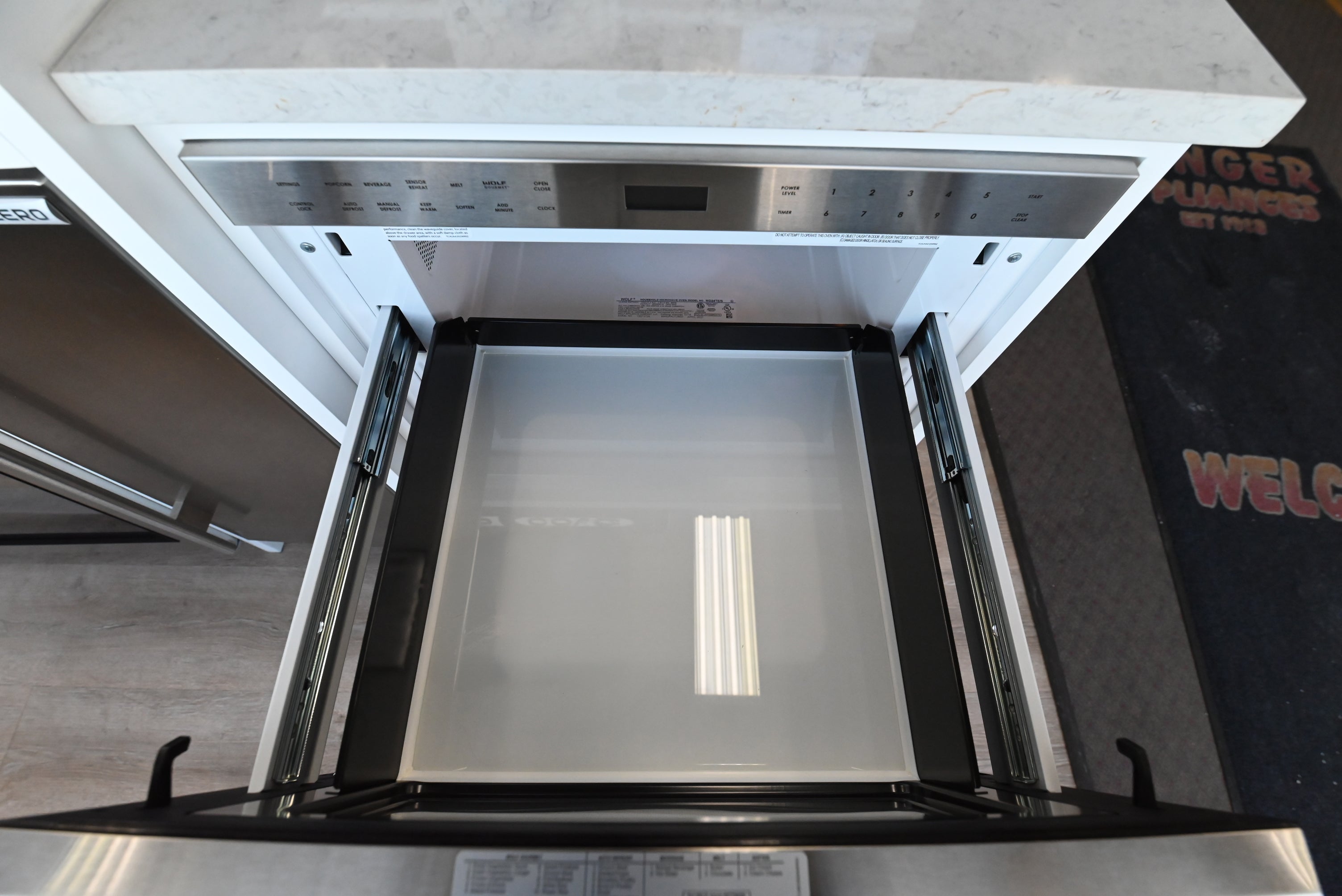 Luxury under counter 24 inch microwave drawer by Wolf showing open cavity holding large pan