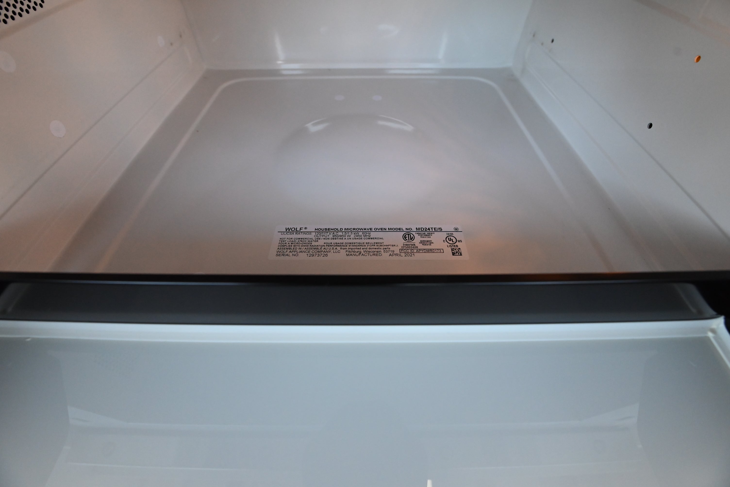 Wolf 24 inch drawer microwave showing hidden top mounted digital controls and flush trim