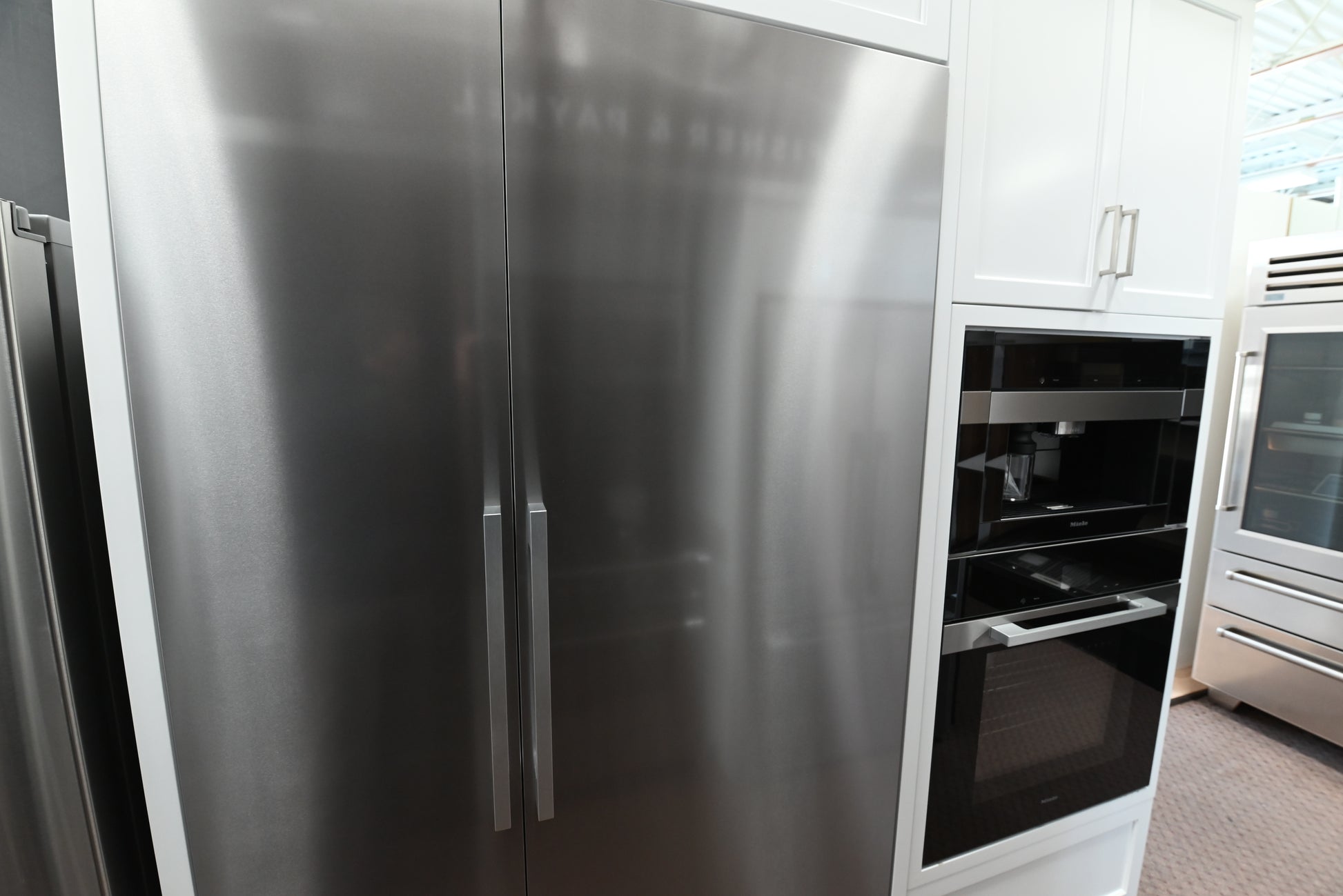 Miele MasterCool 30 inch column fridge showing open door glass shelving and bright LED lights