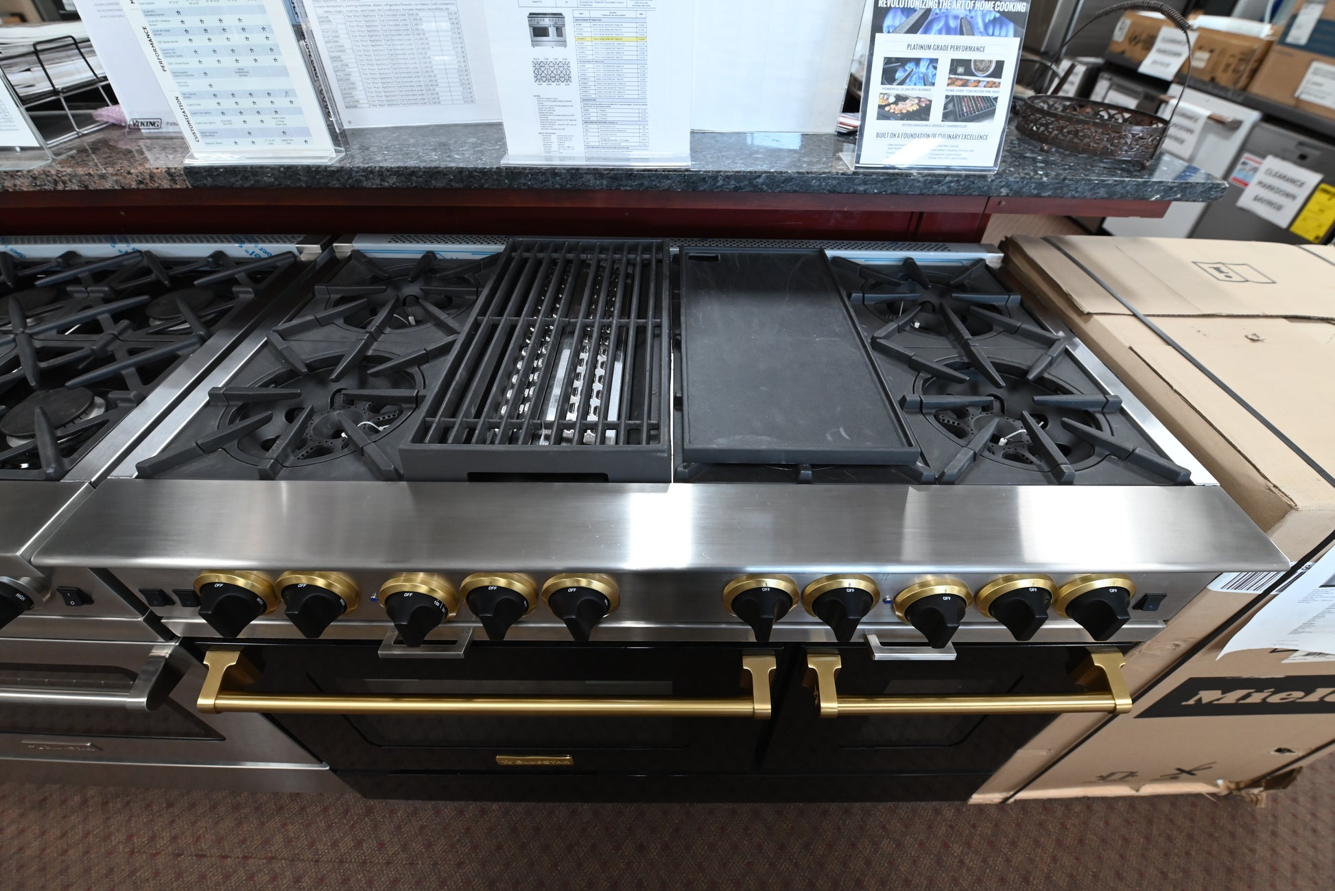 Luxury 48 inch black gas range with 8 open burners and polished brass knobs by BlueStar