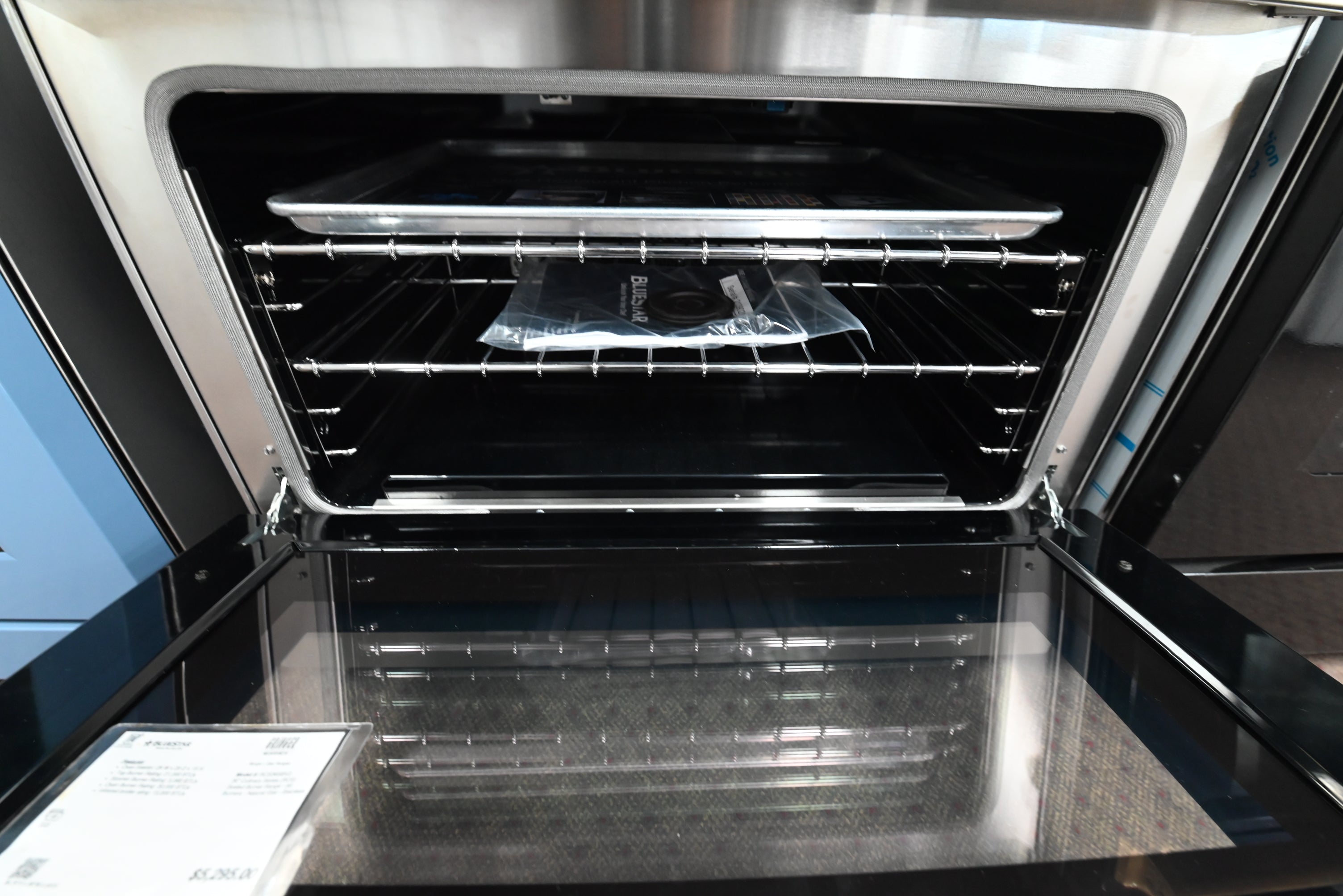 BlueStar gas range showing open convection oven cavity holding full size baking sheet