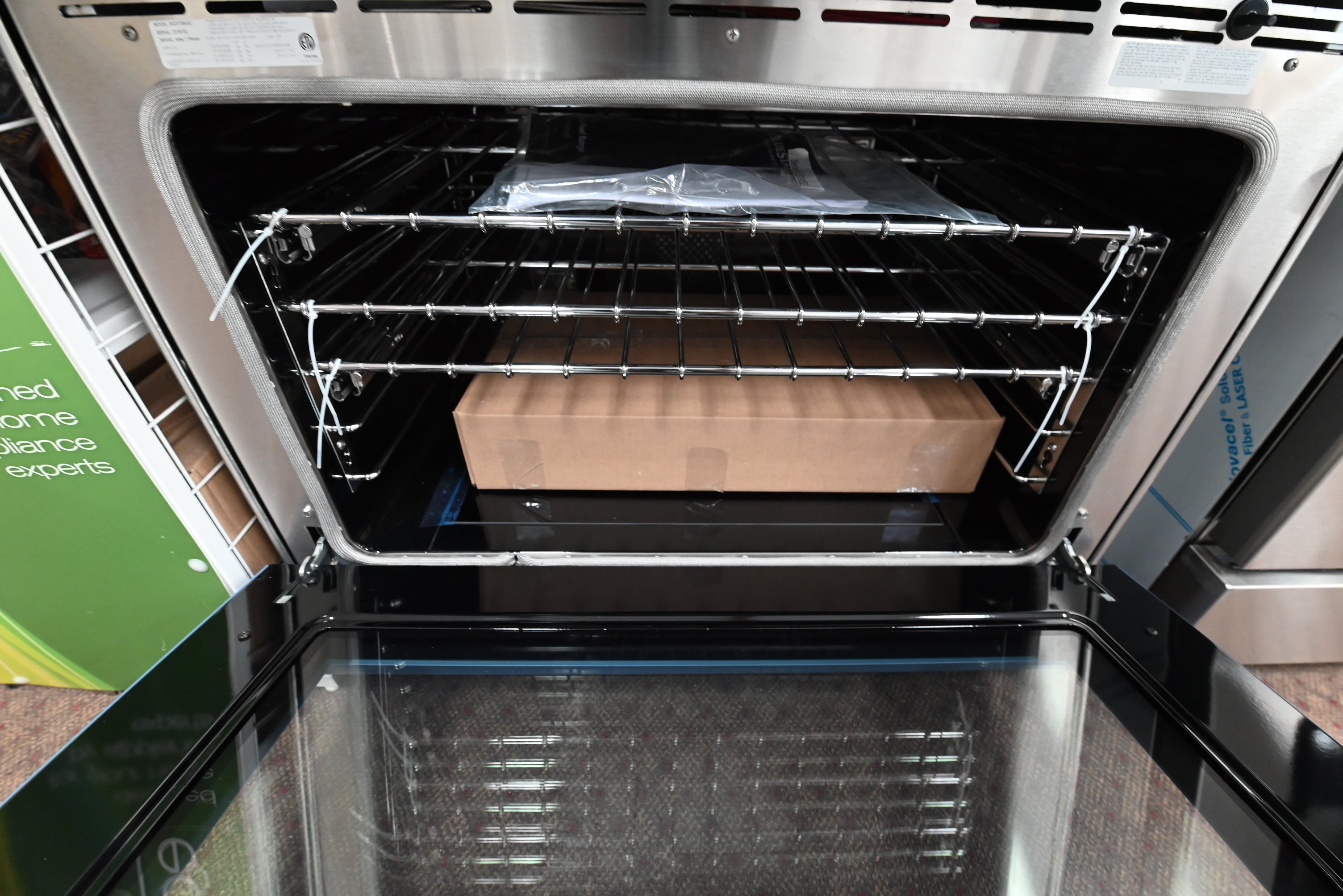 BlueStar dual fuel range showing open electric convection oven cavity holding full glide racks