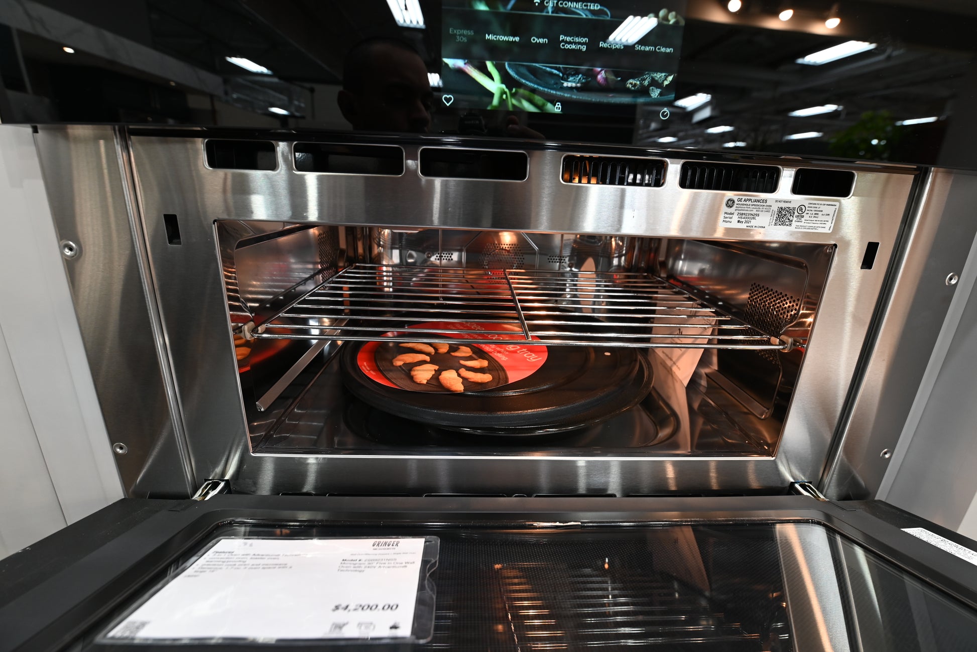 Luxury 30 inch advantium speed oven open showing stainless steel interior cavity and heavy metal cooking turntable