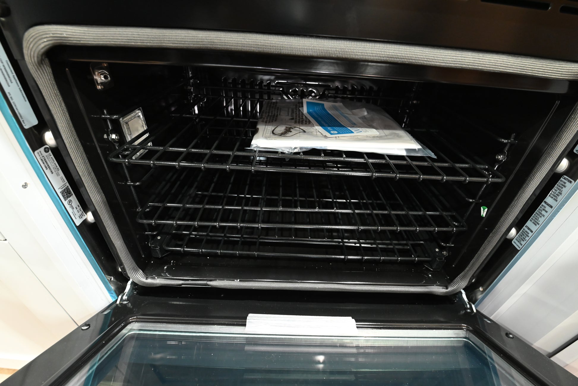 Luxury 30 inch single wall oven open showing large 5.0 cu ft cobalt blue porcelain interior and heavy ball bearing glide racks
