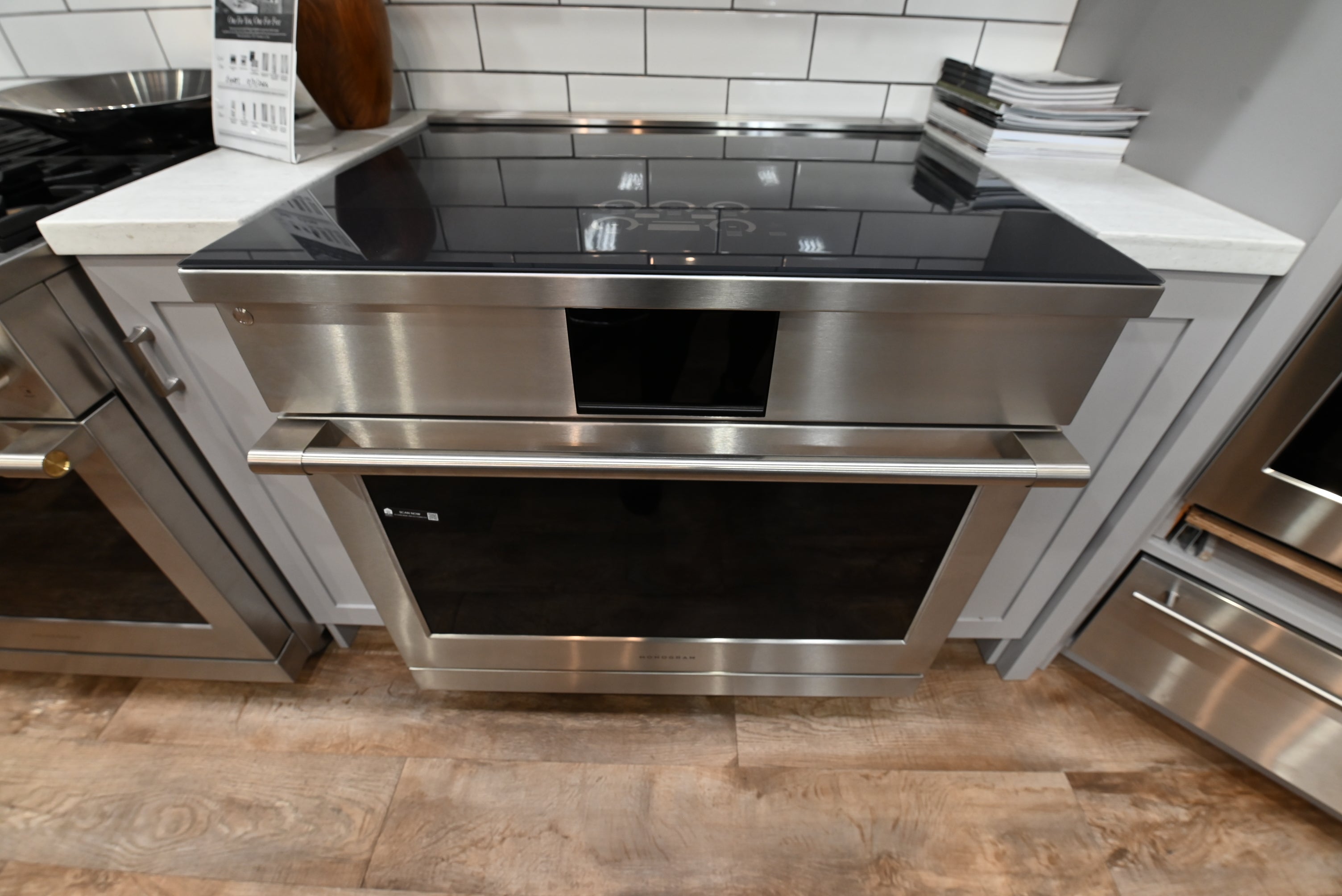 Monogram ZHP365ETVSS 36 inch professional induction range in stainless steel with a seamless black glass cooktop and brass-accented handle
