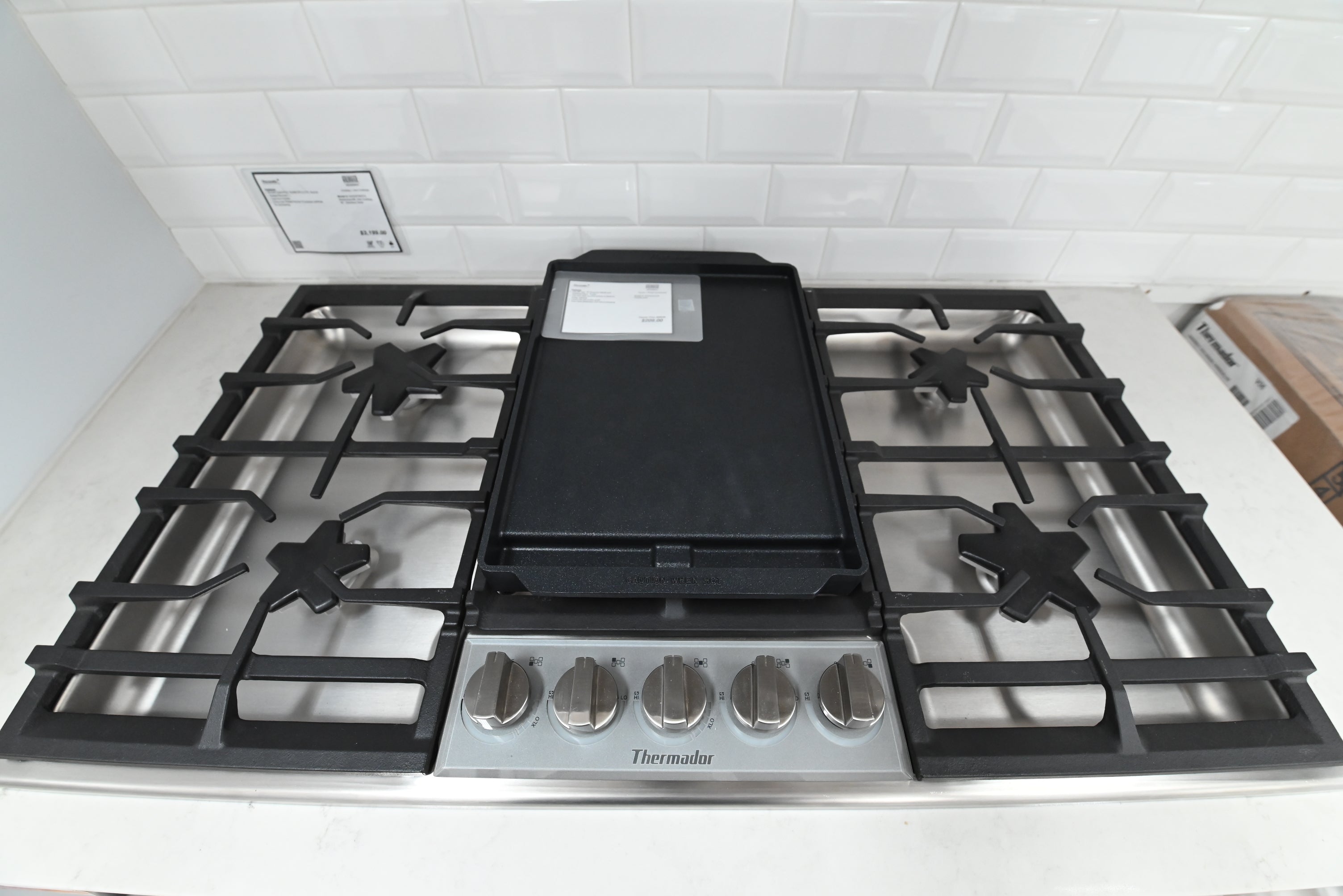 Luxury 36 inch drop in gas cooktop showing 5 raised Pedestal Star Burners and illuminated light ring knobs