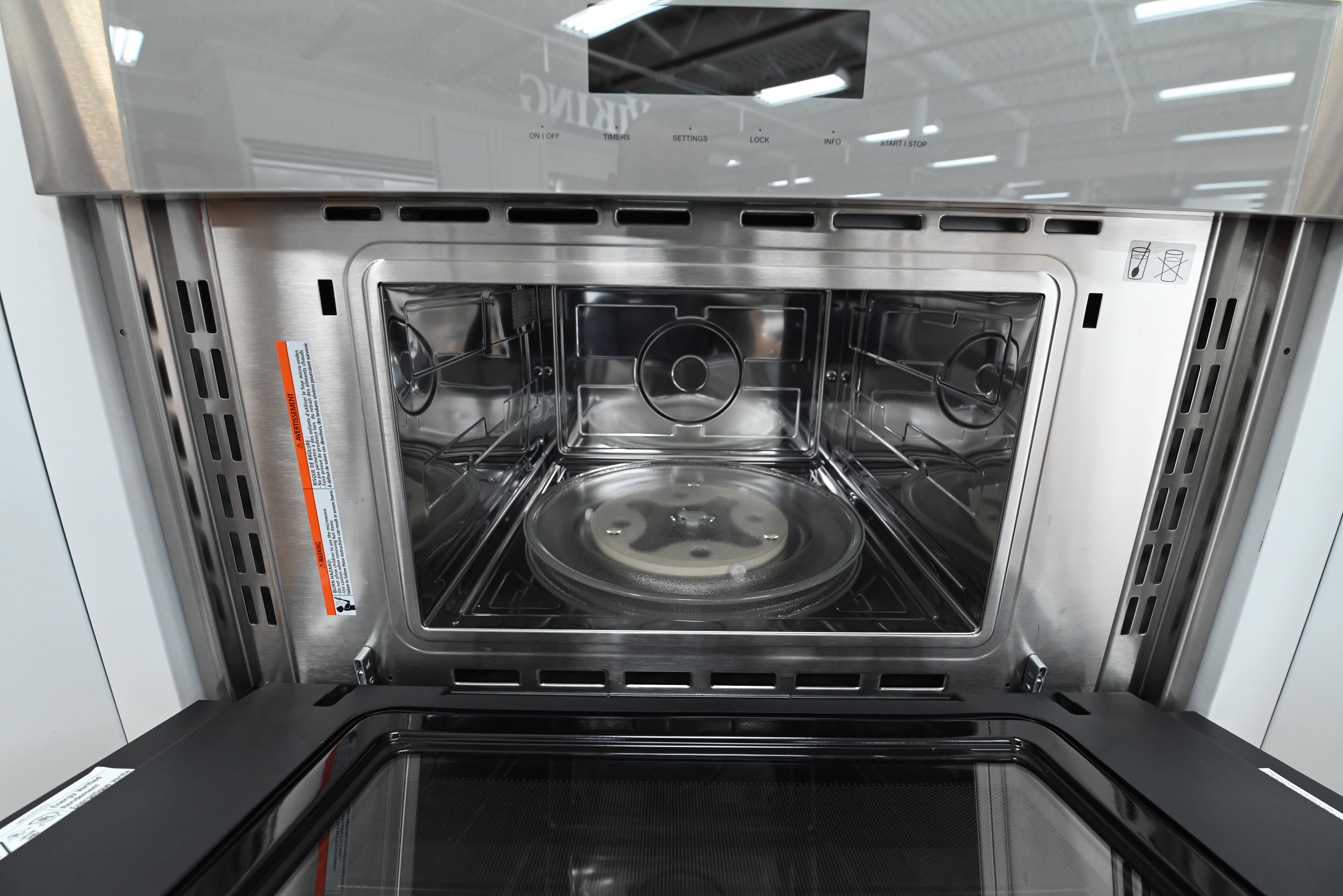 Luxury 30 inch wall microwave open downward showing stainless steel interior and wire shelf