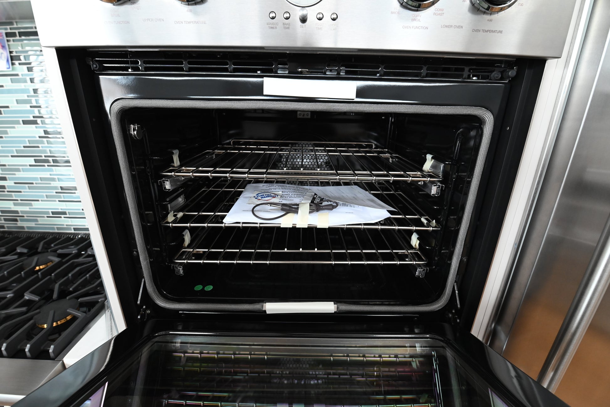 Luxury 30 inch double stacked built in wall oven with doors open showing spacious porcelain interiors and chrome racks