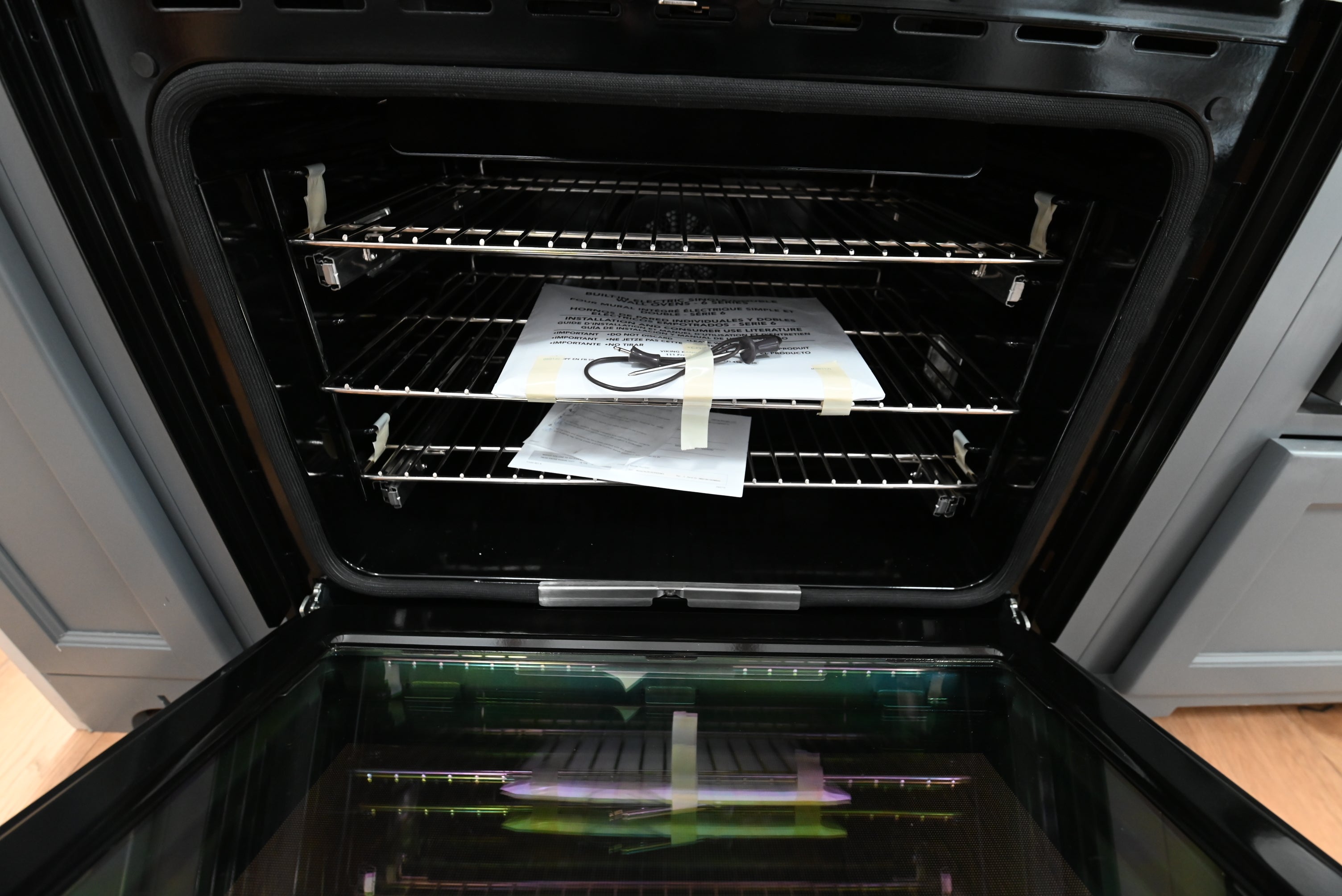 Luxury 30 inch integrated wall oven open showing blue porcelain cavity and two TruGlide extension racks