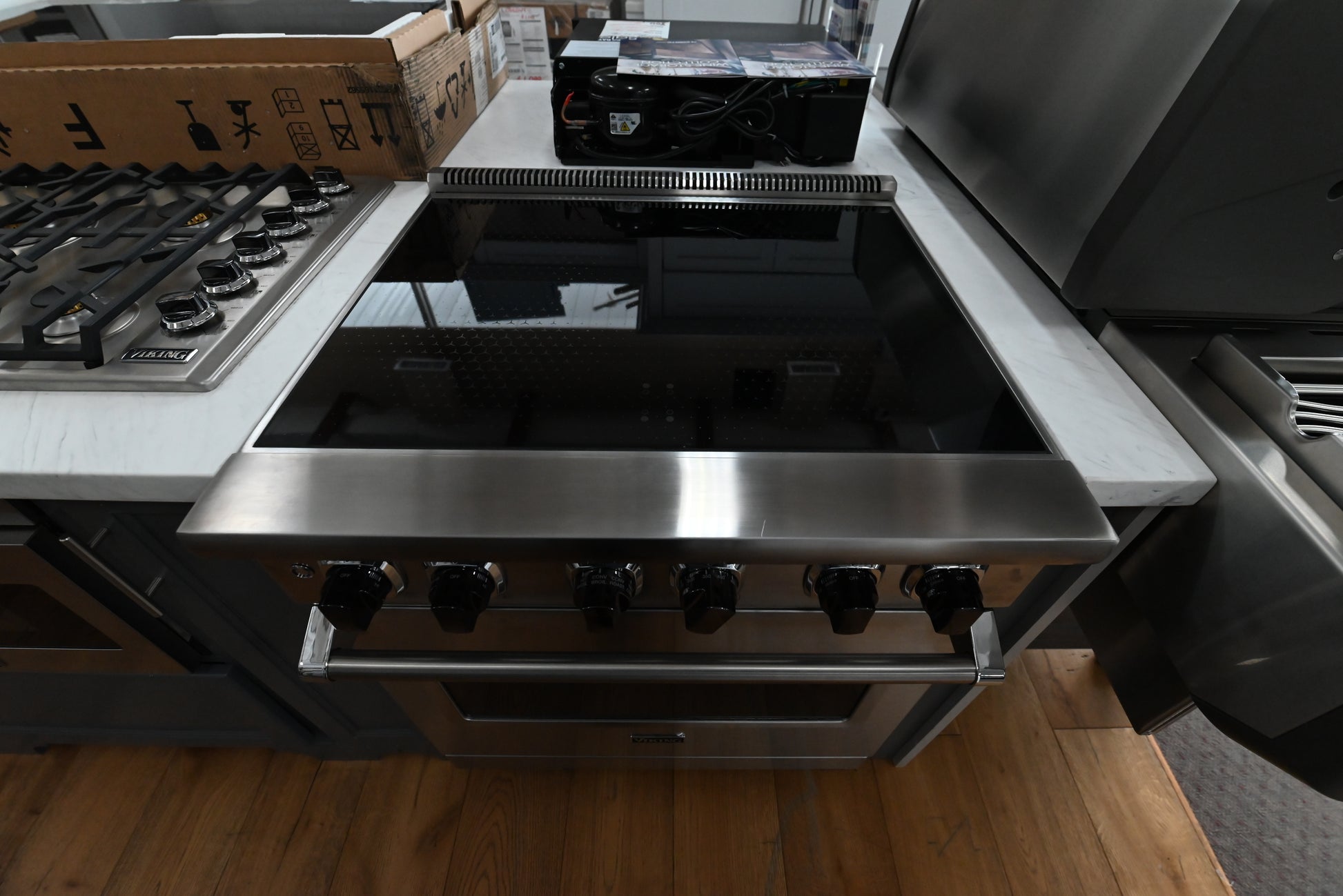 Luxury 30 inch induction range cooktop showing four cooking zones on smooth black glass deck