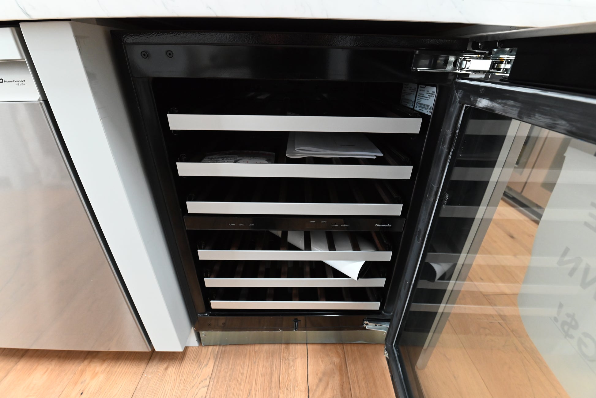 Luxury 24 inch undercounter wine cooler open showing 41 bottle capacity and dark Wenge wood shelves