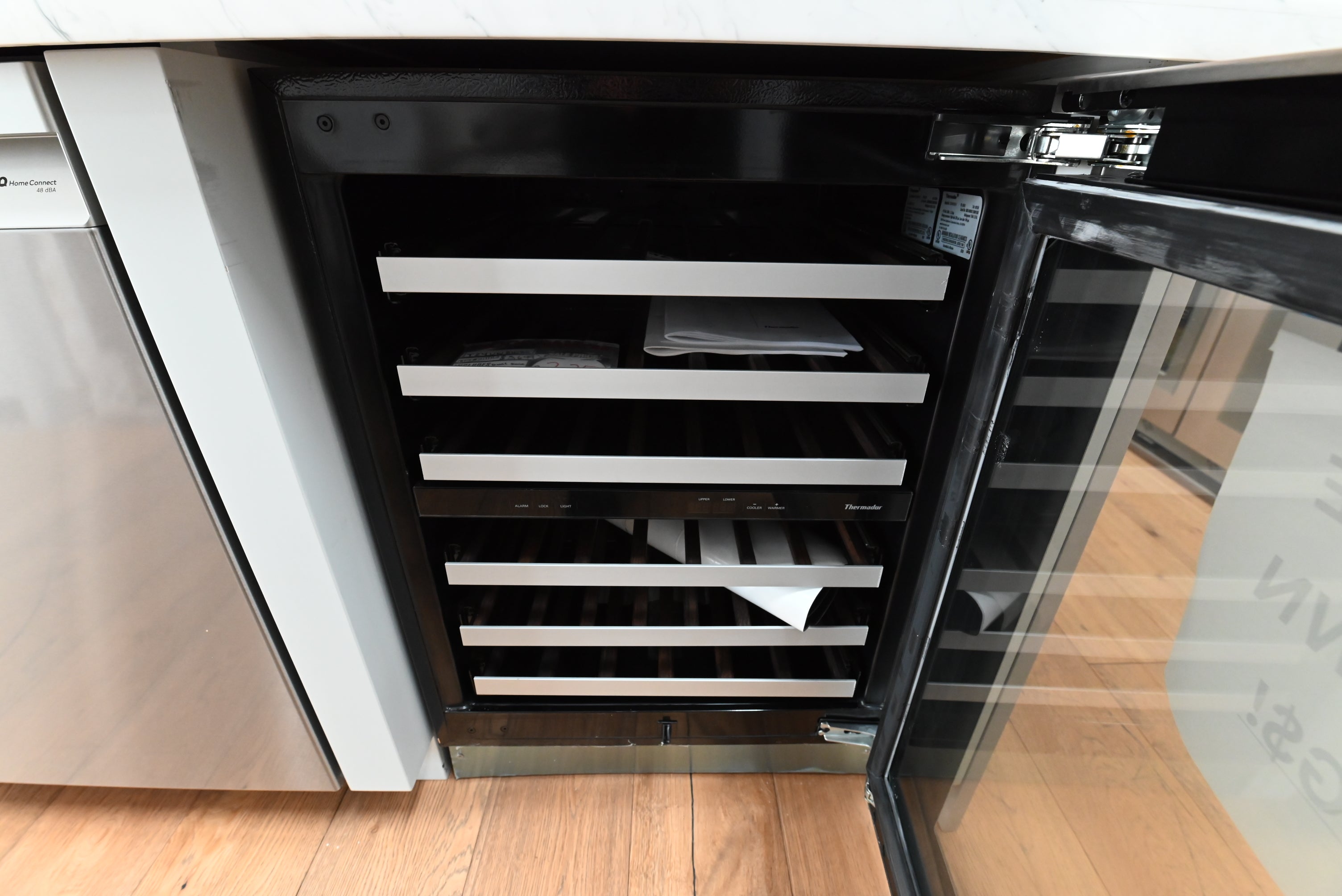 Luxury 24 inch undercounter wine cooler open showing 41 bottle capacity and dark Wenge wood shelves