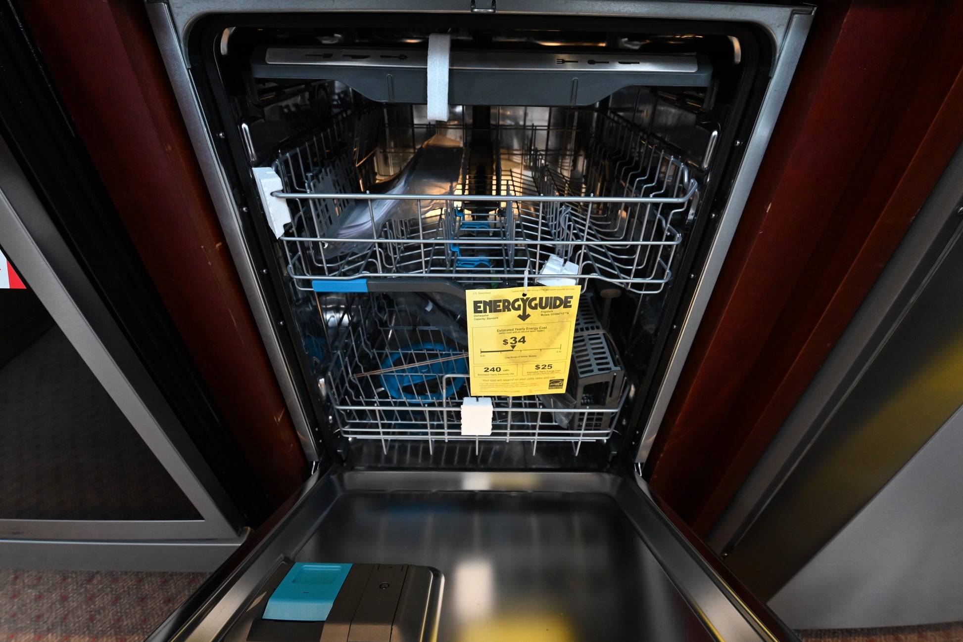 Luxury dishwasher open showing clean stainless steel interior tub racks and lower OrbitClean spray arm