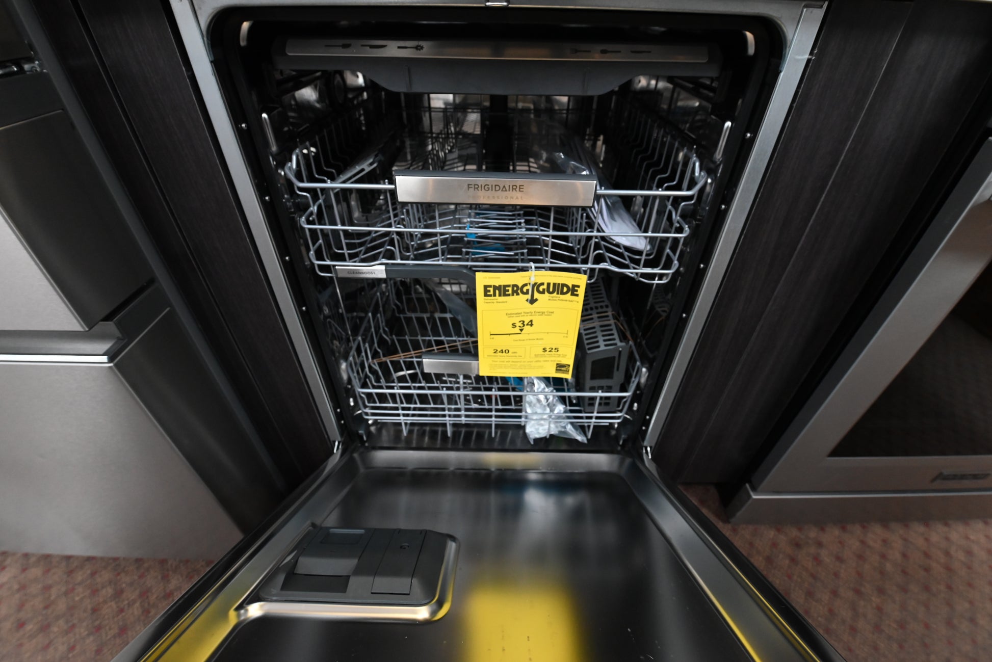 Luxury built in dishwasher open looking inside showing stainless steel tub three racks and utensil tray