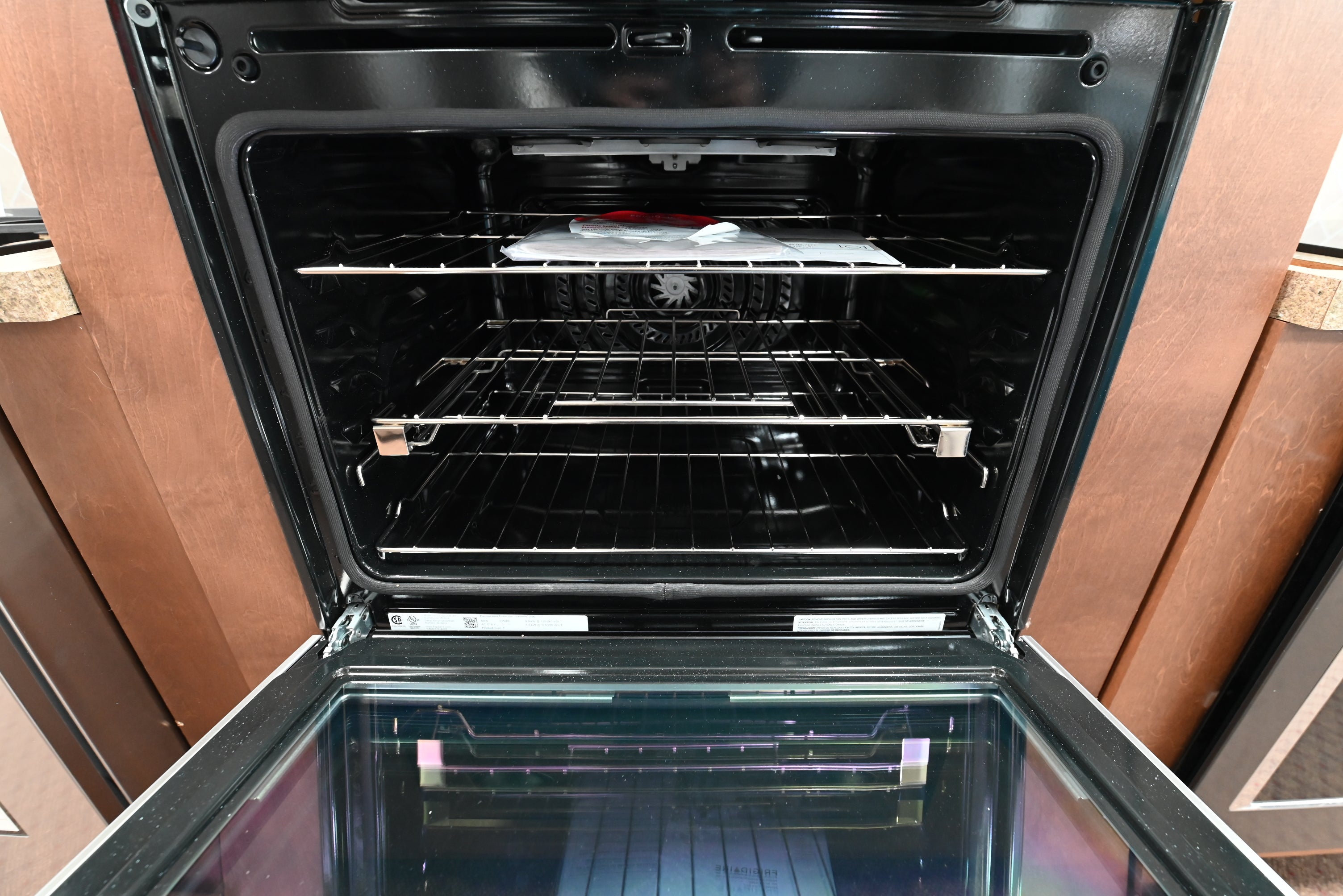 Frigidaire Gallery 30 inch double convection wall oven installed flush into dark wood custom cabinetry