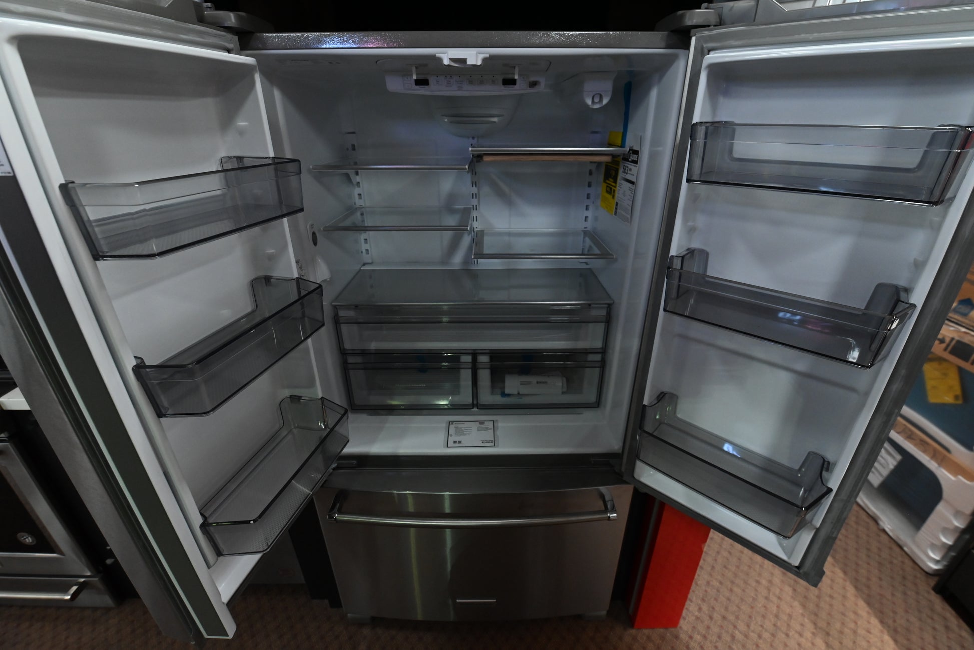 Luxury modern 36 inch French door refrigerator open doors showing interior glass shelves and pantry drawer