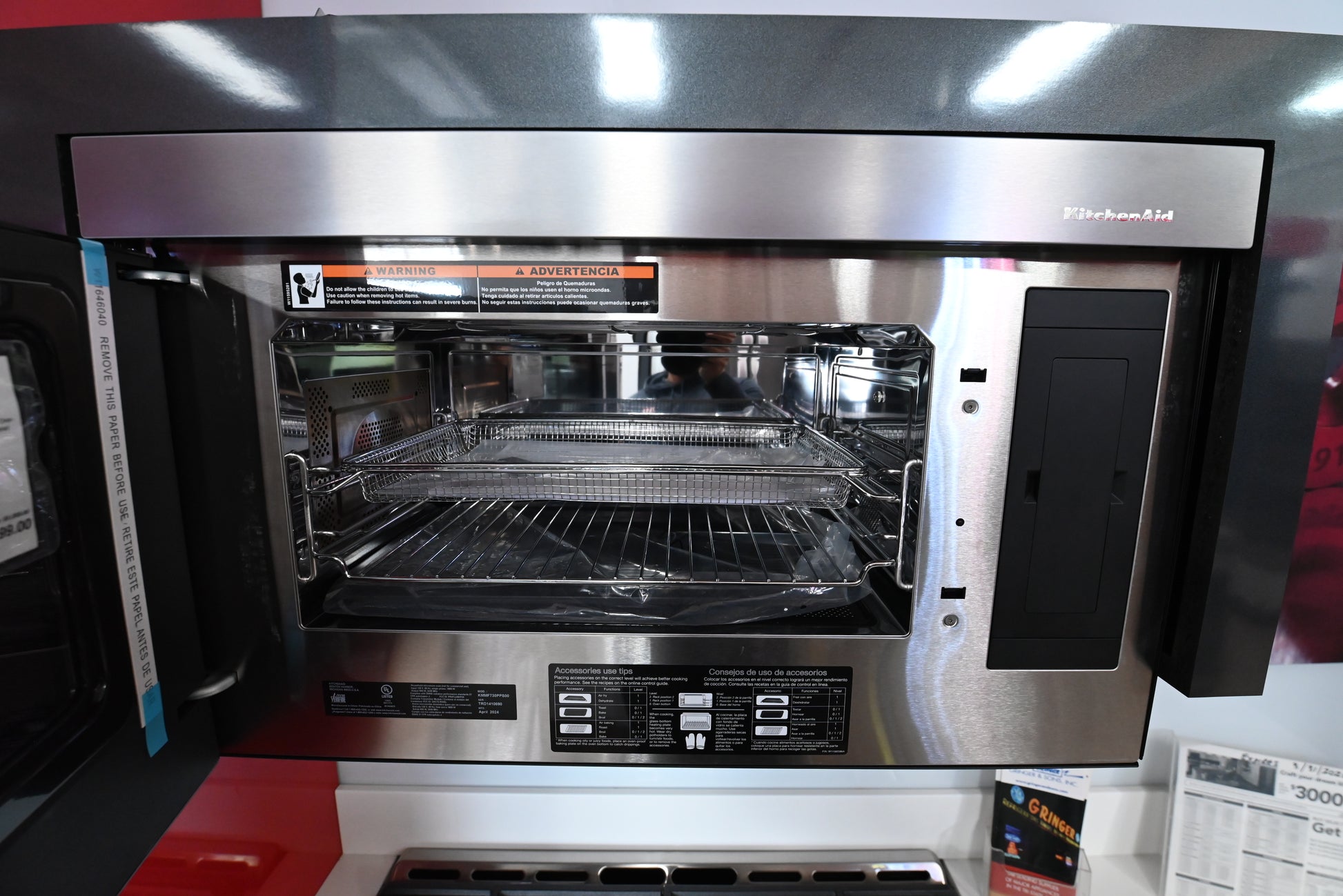 Premium slim over the range KitchenAid microwave open showing turntable cavity above a cooktop layout