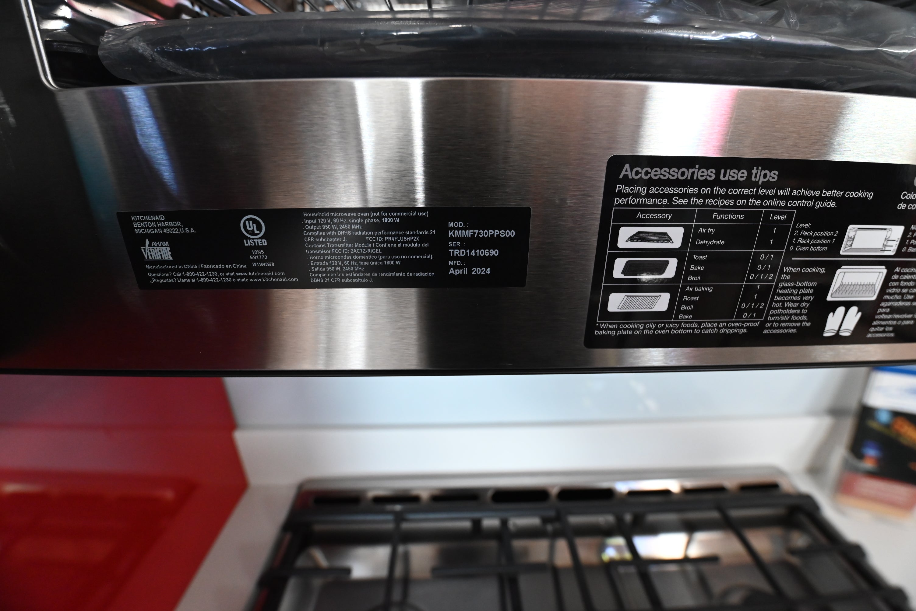 Modern low profile kitchen microwave hood combo showing illuminated hidden touch controls and clean stainless steel lines