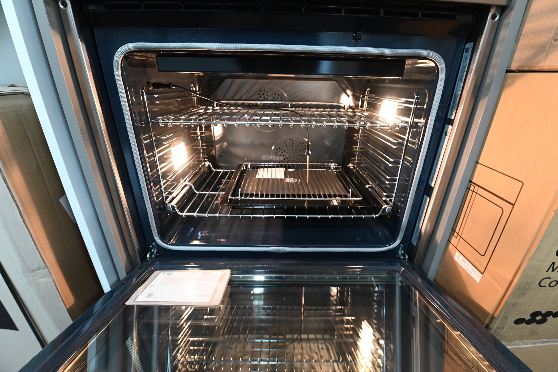 Luxury 30 inch built in wall oven door open showing blue porcelain cavity and telescopic glide rack