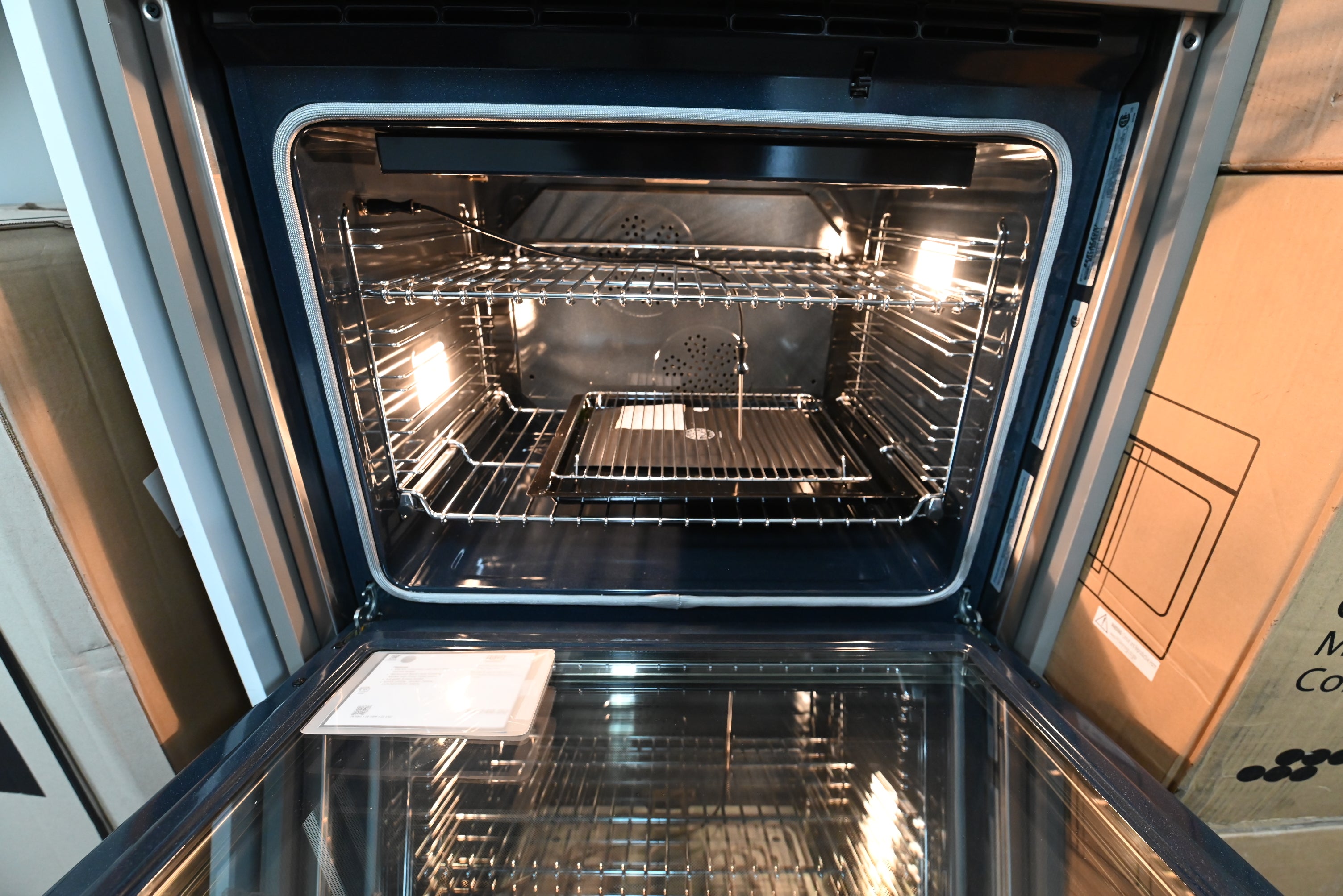 Luxury 30 inch built in wall oven door open showing blue porcelain cavity and telescopic glide rack