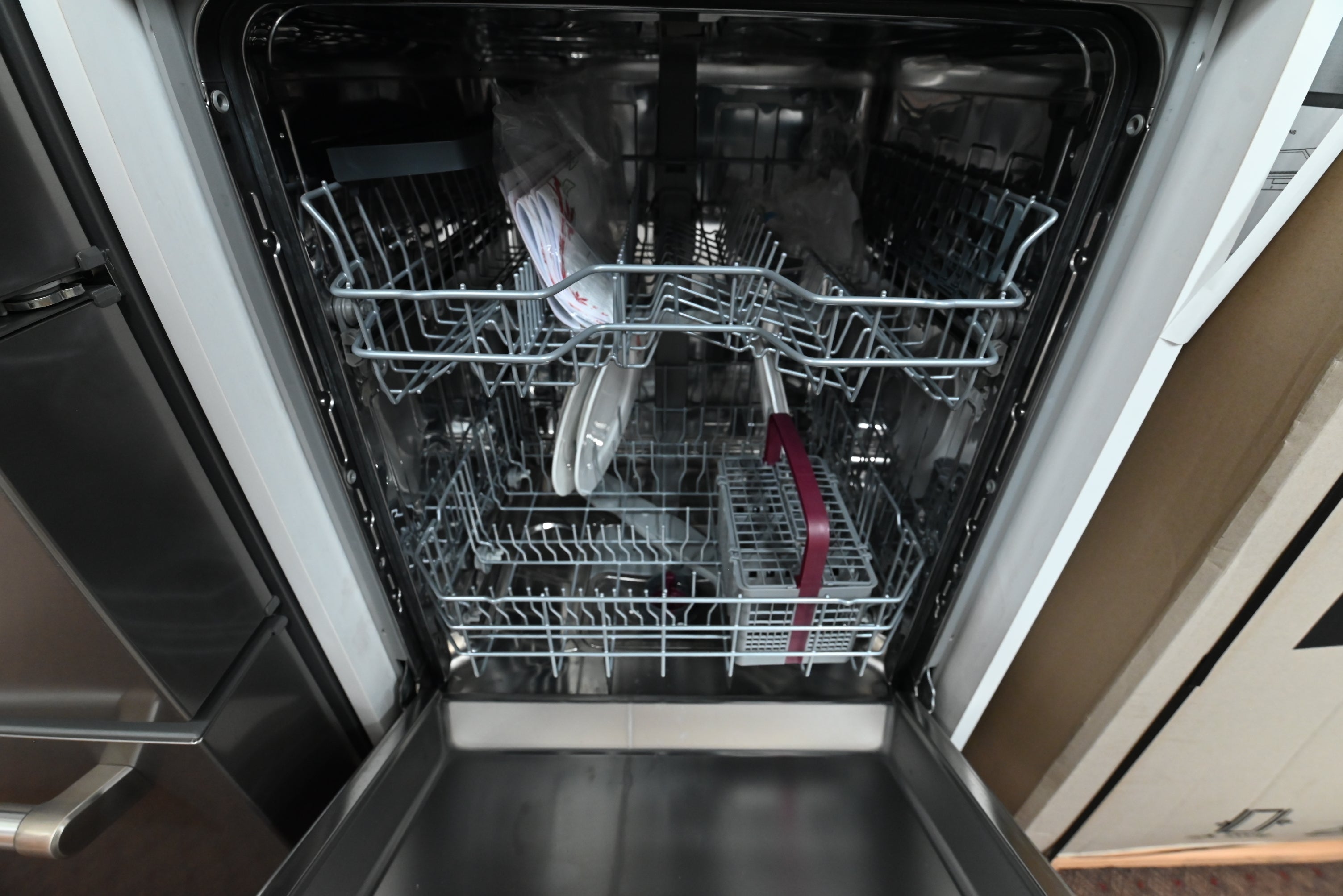 Luxury 24 inch tall tub dishwasher open showing full stainless steel interior tank and flexible rack loading layouts