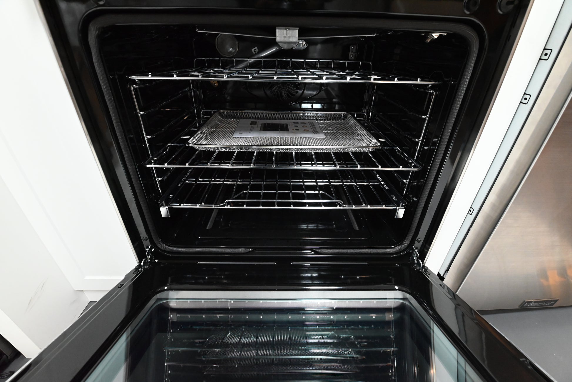 Luxury 30 inch gas slide in range cooktop showing continuous cast iron grates and brass burners by Dacor