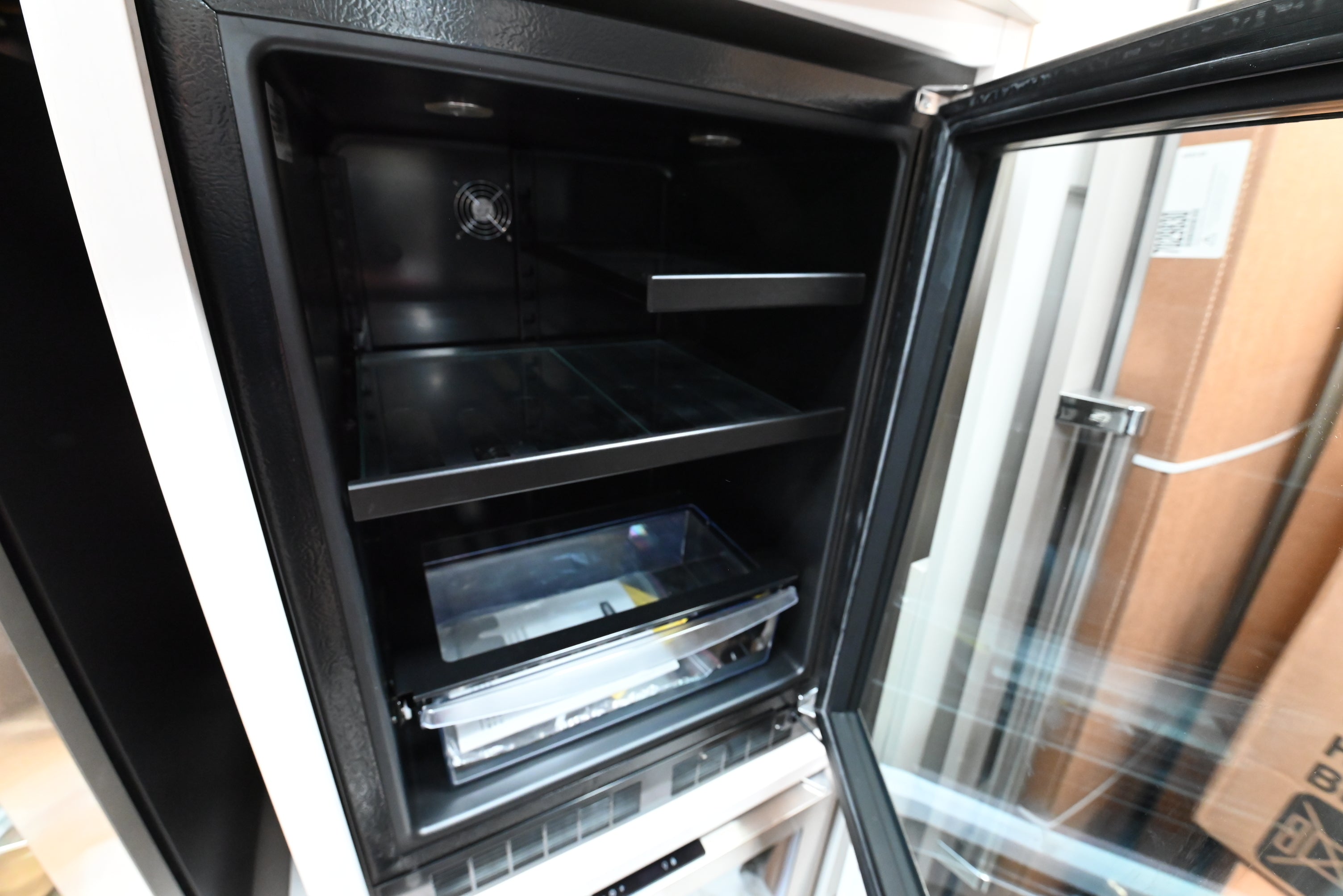 Luxury under counter beverage refrigerator open showing 162 can capacity white LED lighting and clear rollout bin