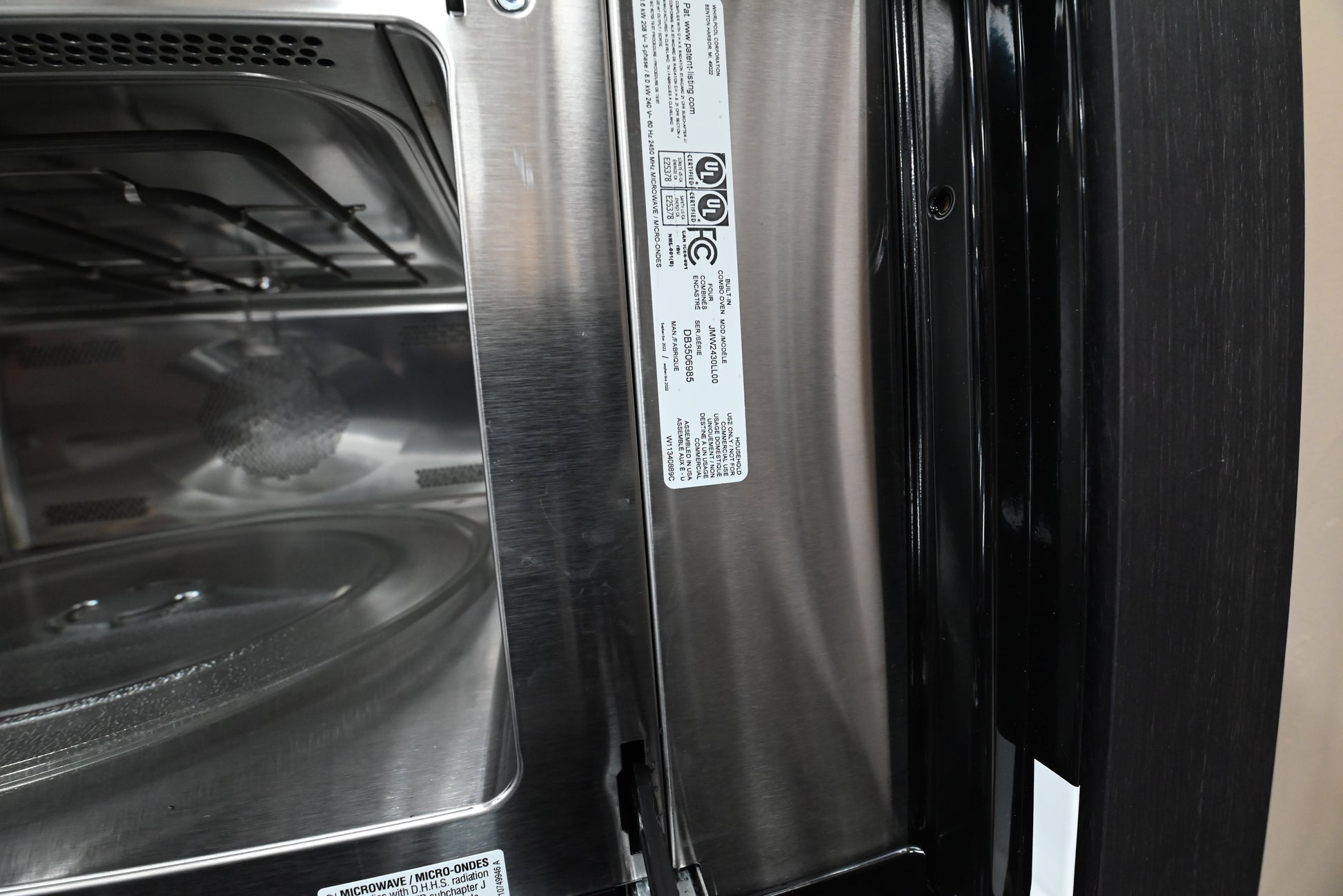 Modern professional kitchen wall featuring an integrated JennAir RISE combination oven flush in wood cabinets