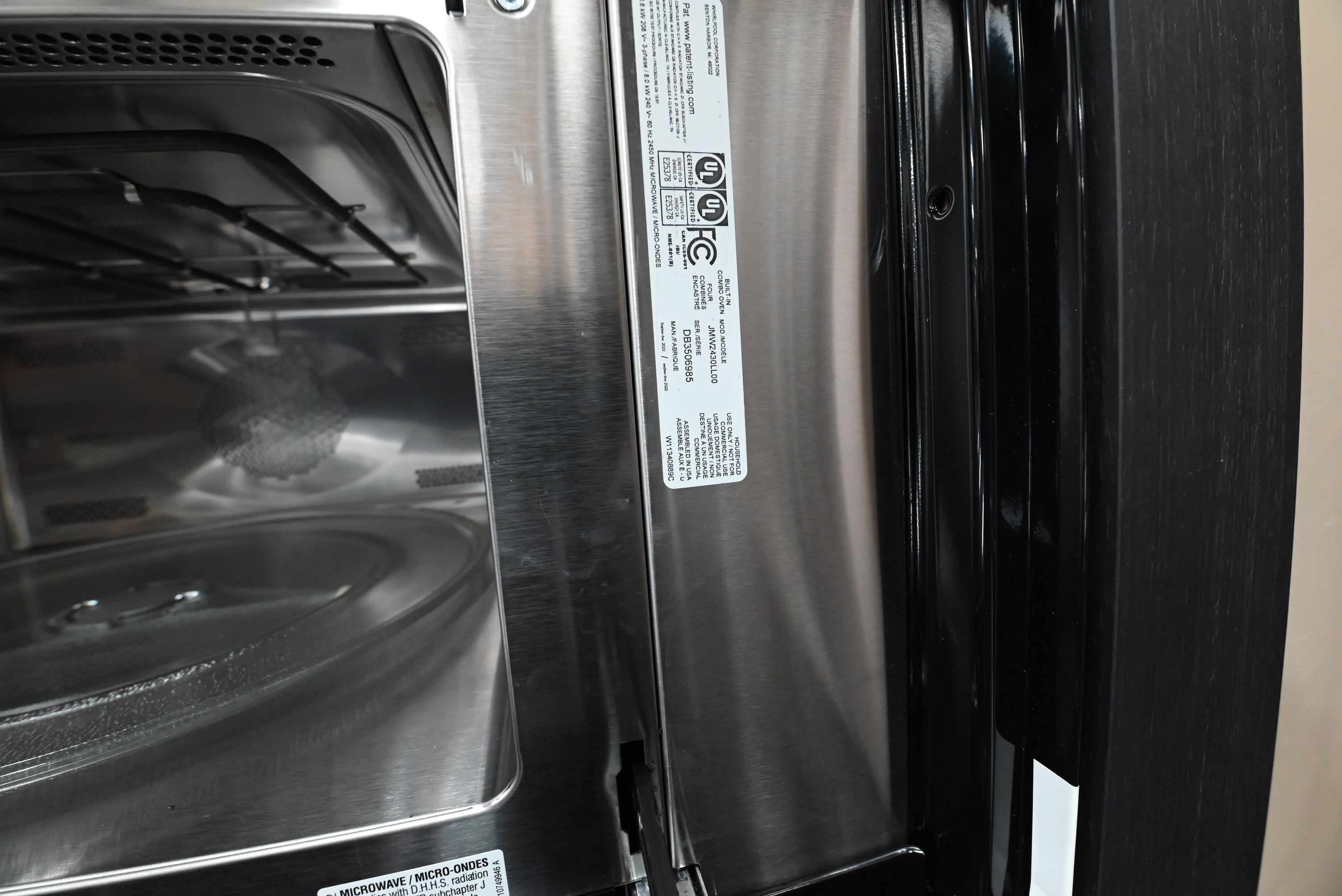 Modern professional kitchen wall featuring an integrated JennAir RISE combination oven flush in wood cabinets
