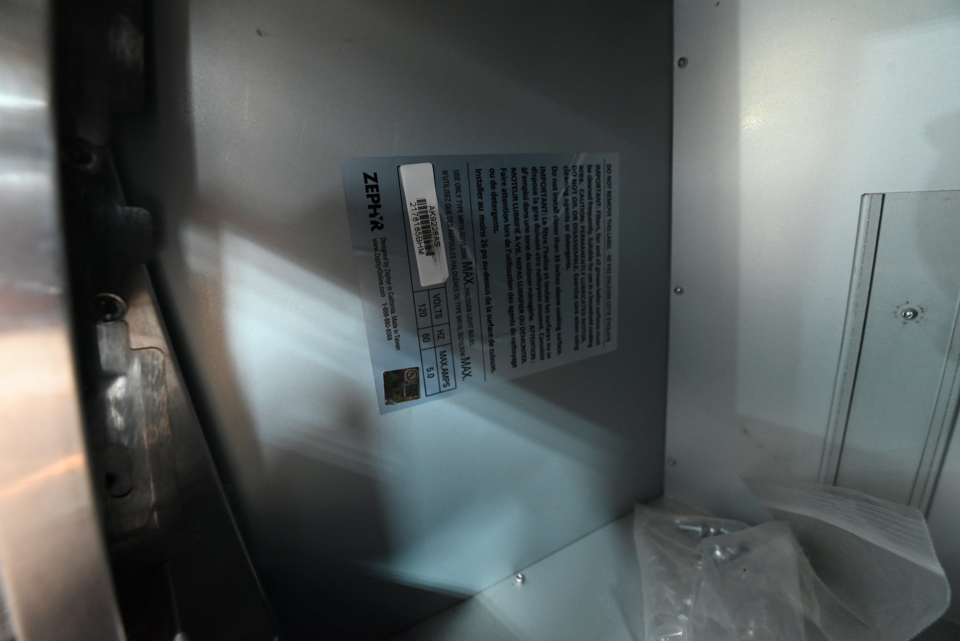 Under cabinet luxury range hood insert looking up showing Zephyr pro baffle filters and dual halogen lamps
