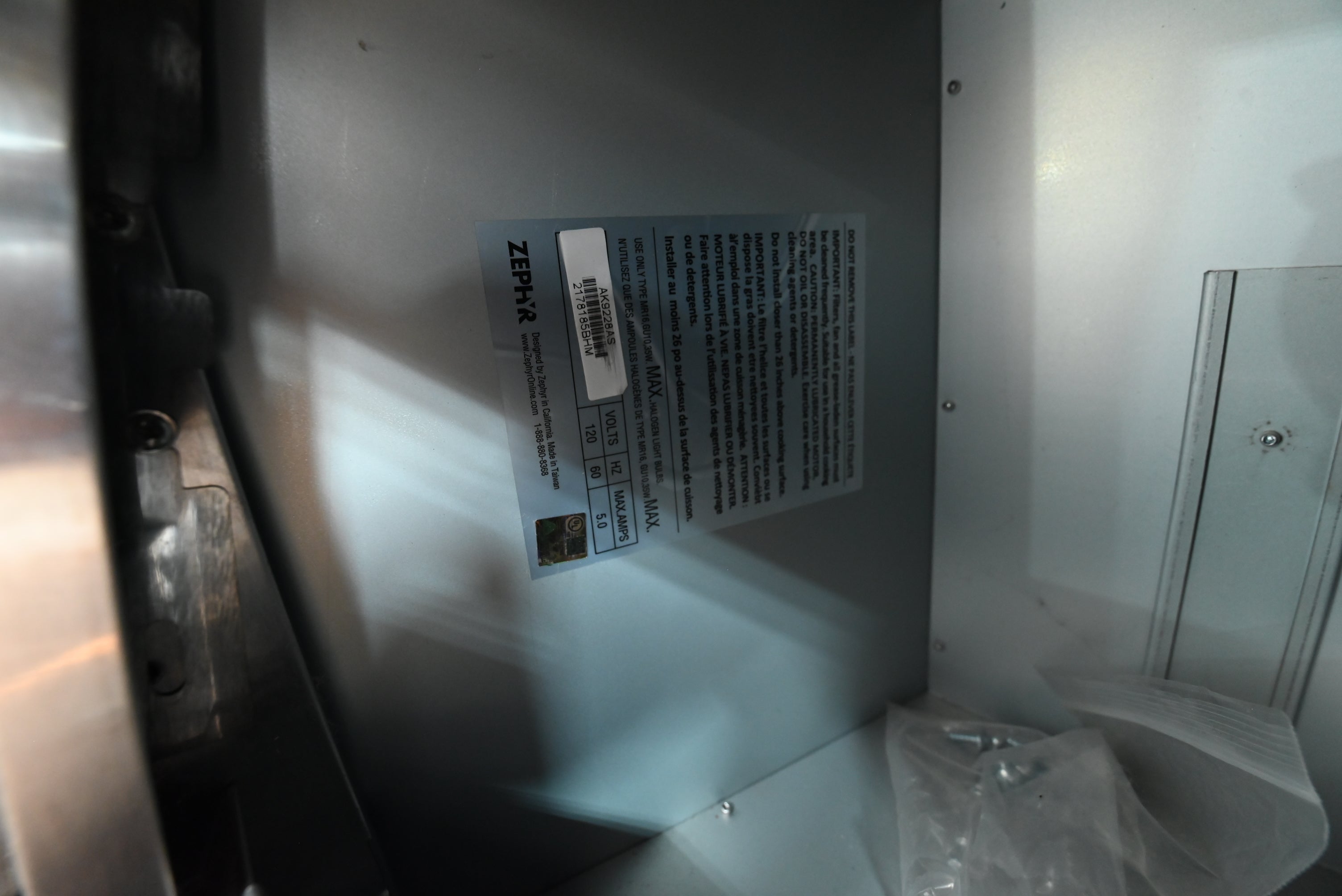 Under cabinet luxury range hood insert looking up showing Zephyr pro baffle filters and dual halogen lamps