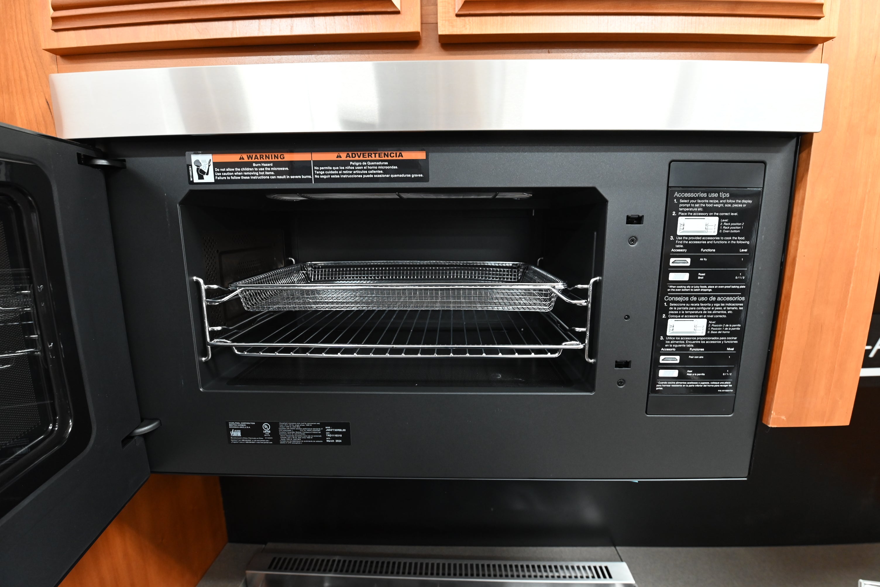 Open door of a flush JennAir microwave hood combo showing dramatic black obsidian interior and glass tray