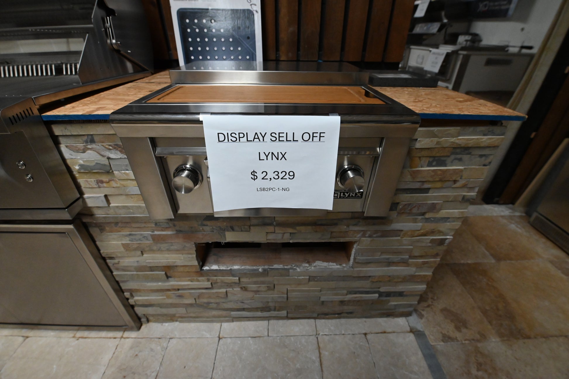 Luxury outdoor island built in side burner station showing brass burners and maple cutting board