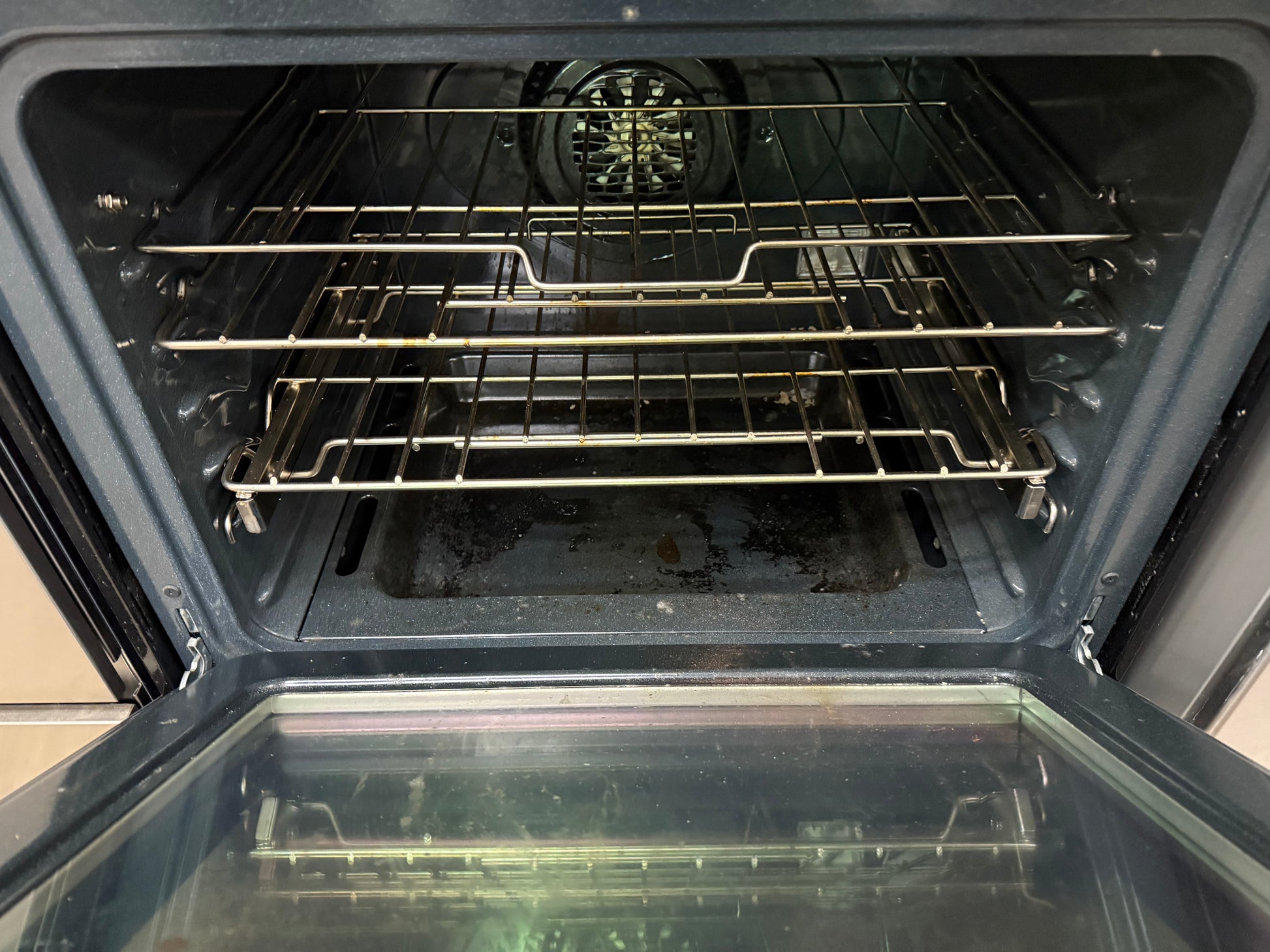 Open oven with racks inside, showing the interior.